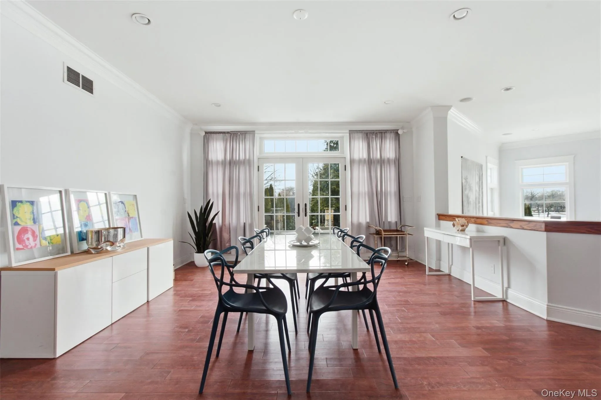 Large open floor plan dining room with wall of window and access to stone patio Large open floor plan dining room with wall of window and access to stone patio