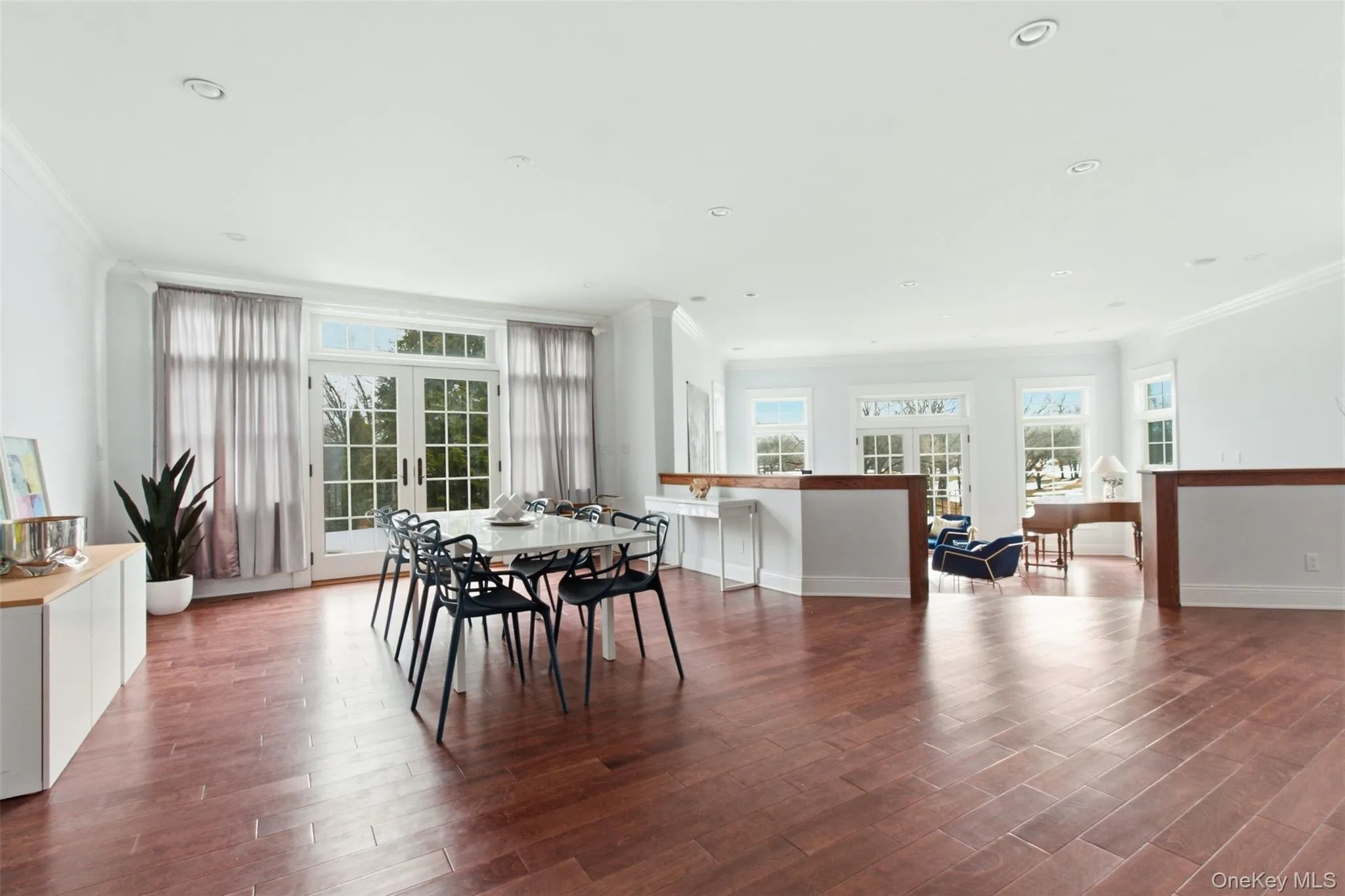 Large open floor plan dining room with wall of window and access to stone patio Large open floor plan dining room with wall of window and access to stone patio