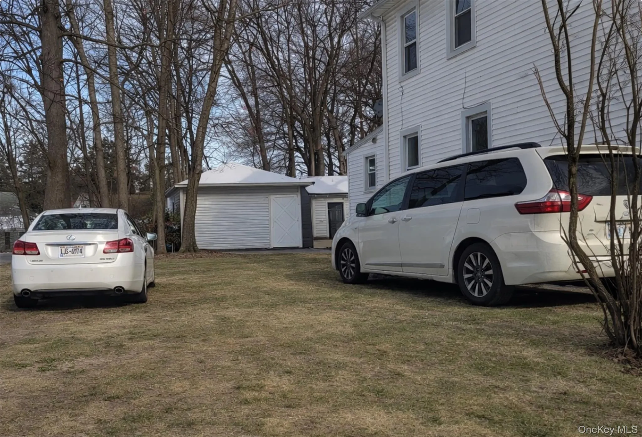 View of side of home featuring an outdoor structure and a yard View of side of home featuring an outdoor structure and a yard