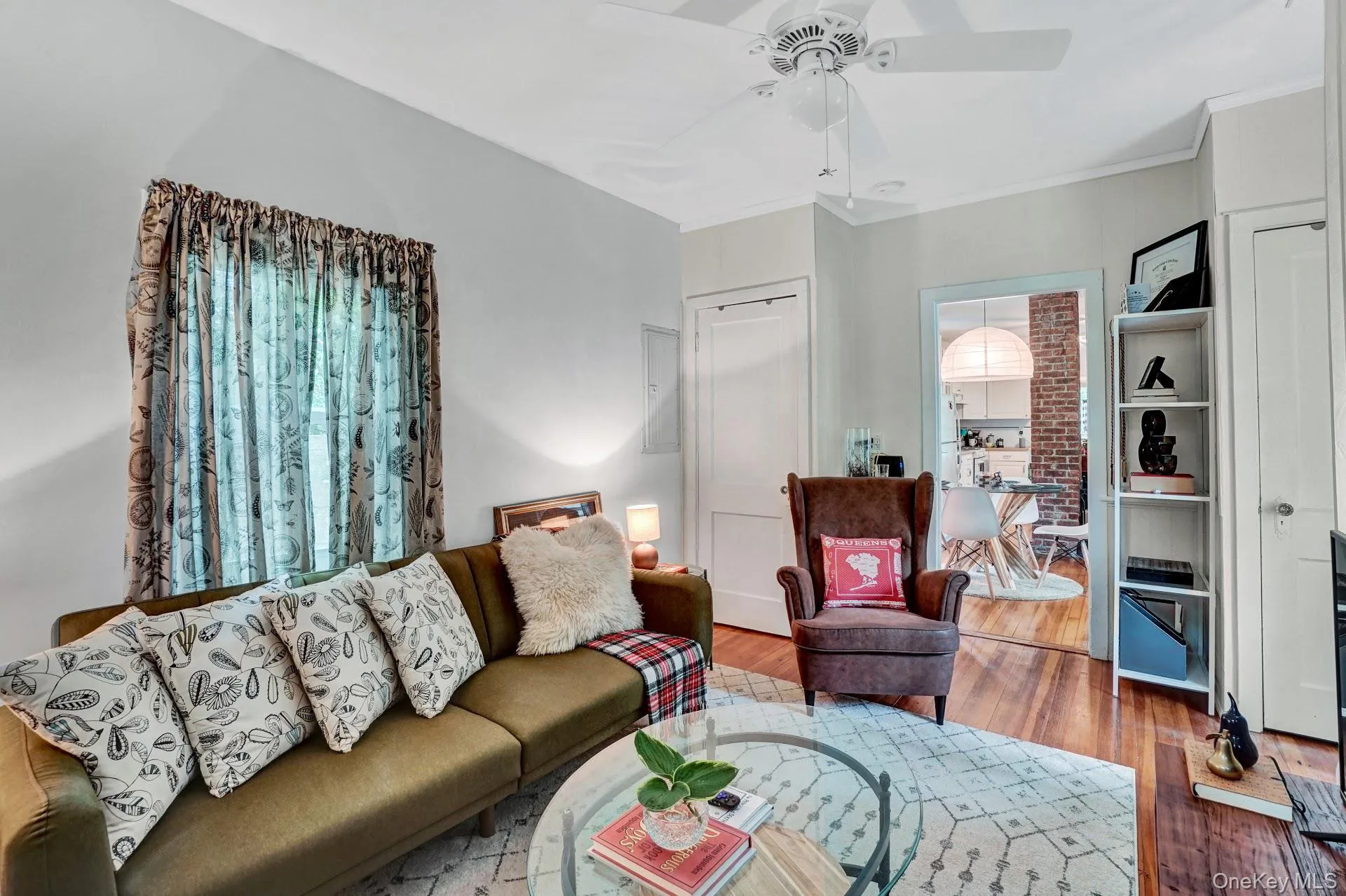 Living area featuring ornamental molding, wood finished floors, and ceiling fan Living area featuring ornamental molding, wood finished floors, and ceiling fan