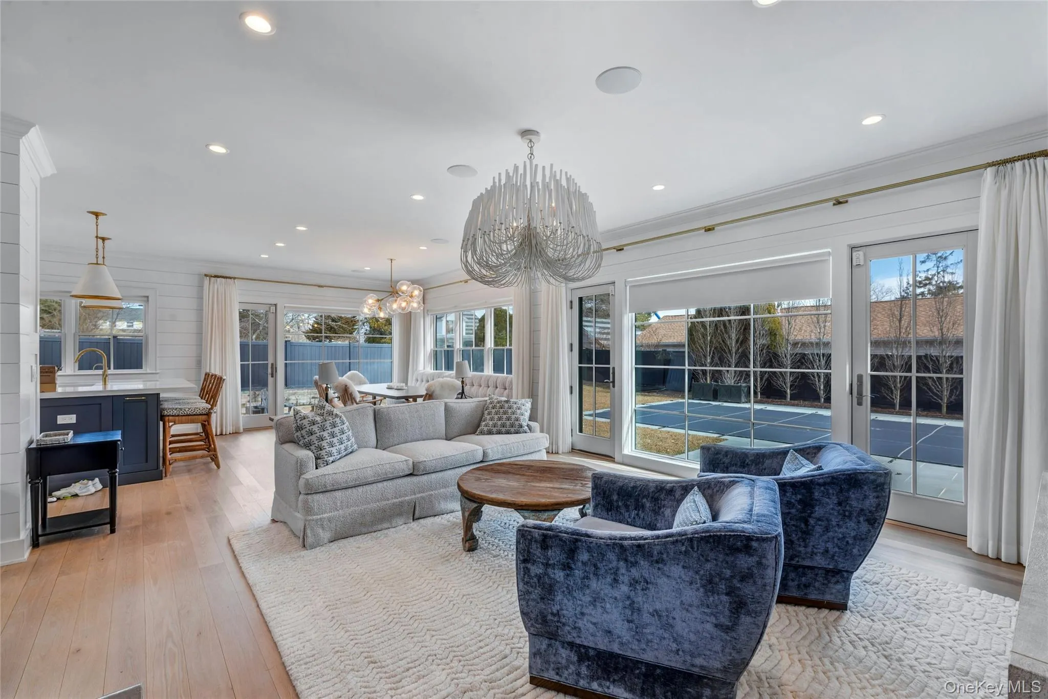 Bright, expansive living room in a New Suffolk retreat featuring floor-to-ceiling windows and abundant natural light Bright, expansive living room in a New Suffolk retreat featuring floor-to-ceiling windows and abundant natural light