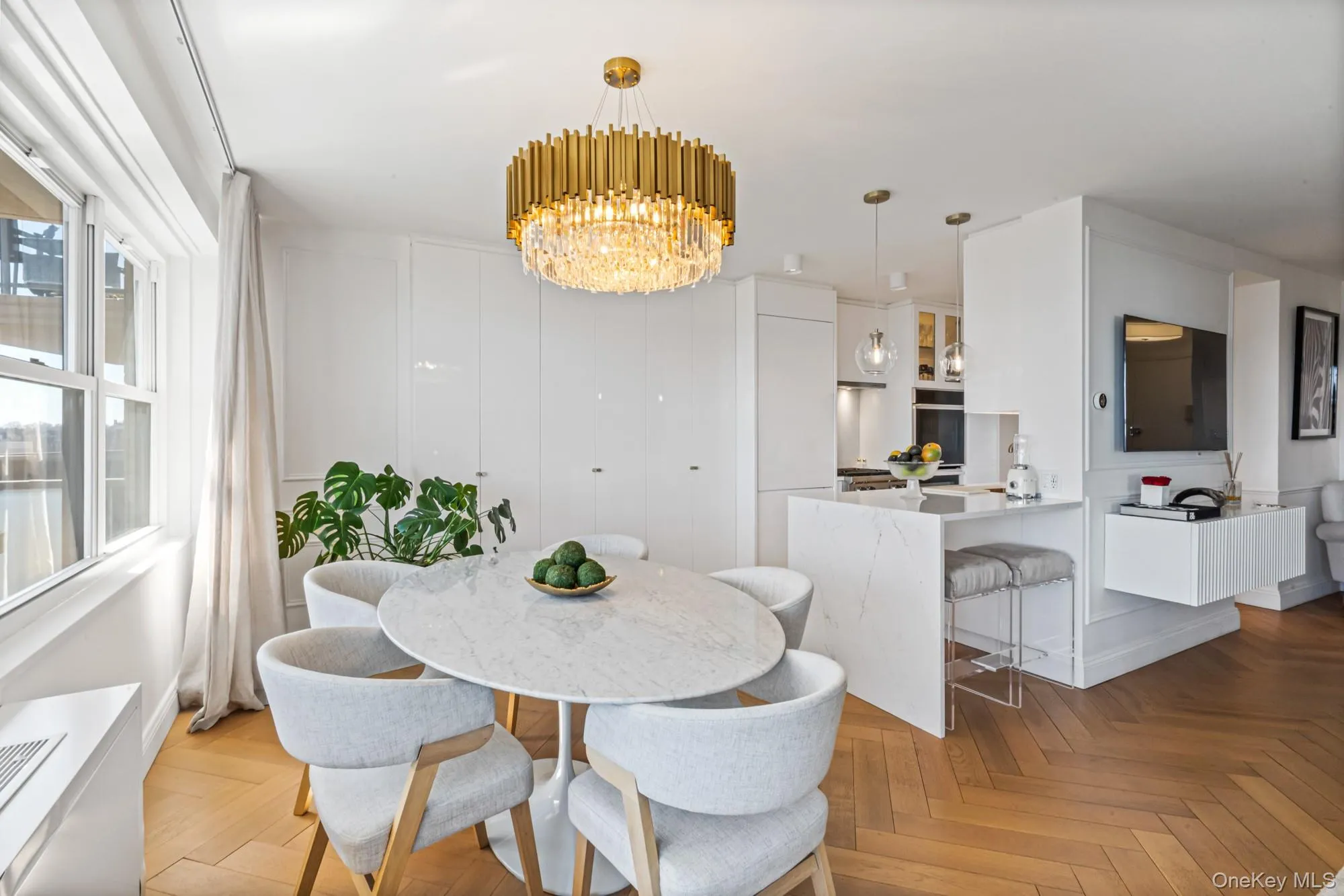 Dining space featuring herringbone parquet flooring, suspended lighting, and a water view Dining space featuring herringbone parquet flooring, suspended lighting, and a water view