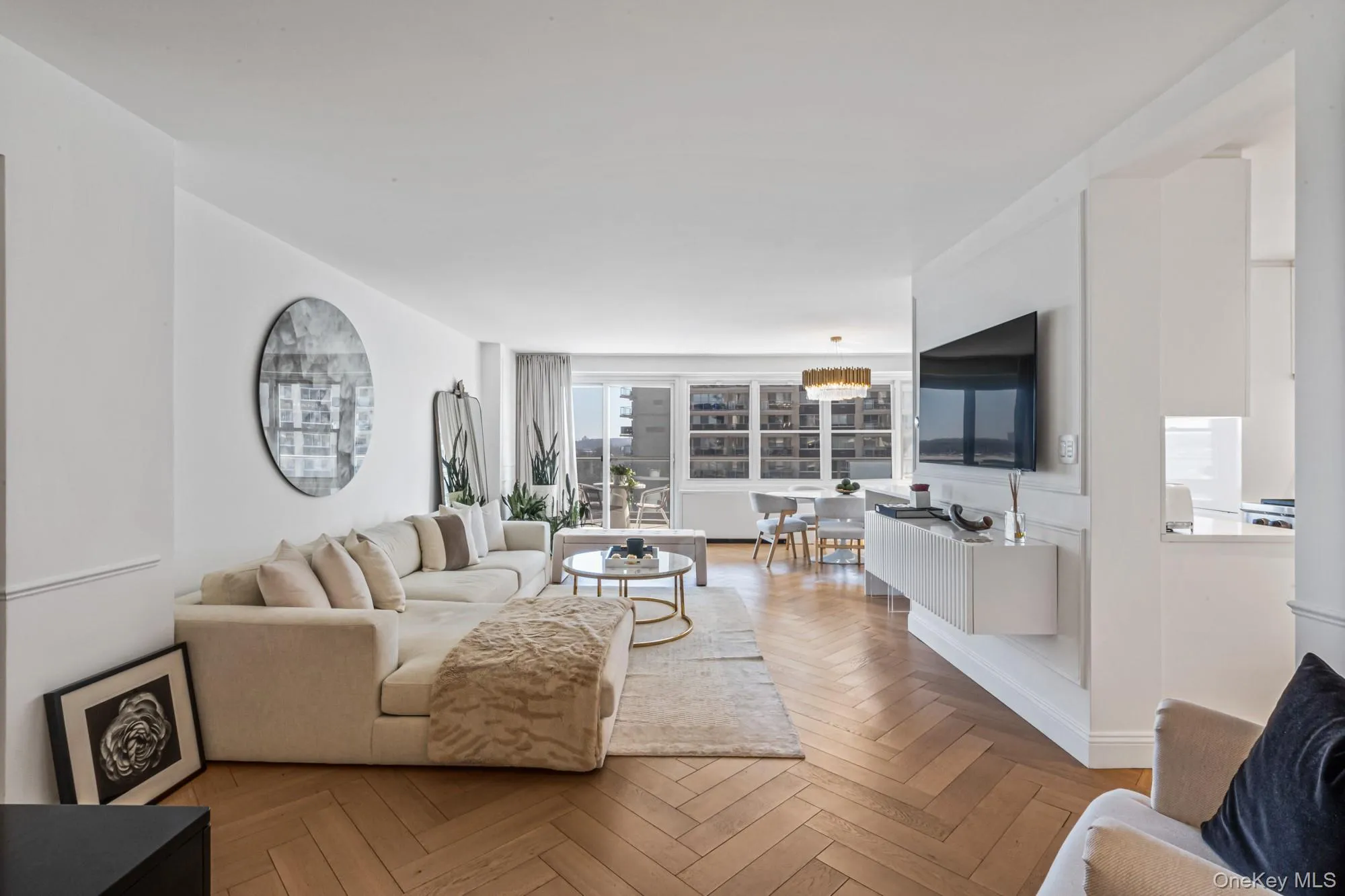 Livingroom featuring herringbone parquet flooring, suspended lighting, and a water view Livingroom featuring herringbone parquet flooring, suspended lighting, and a water view