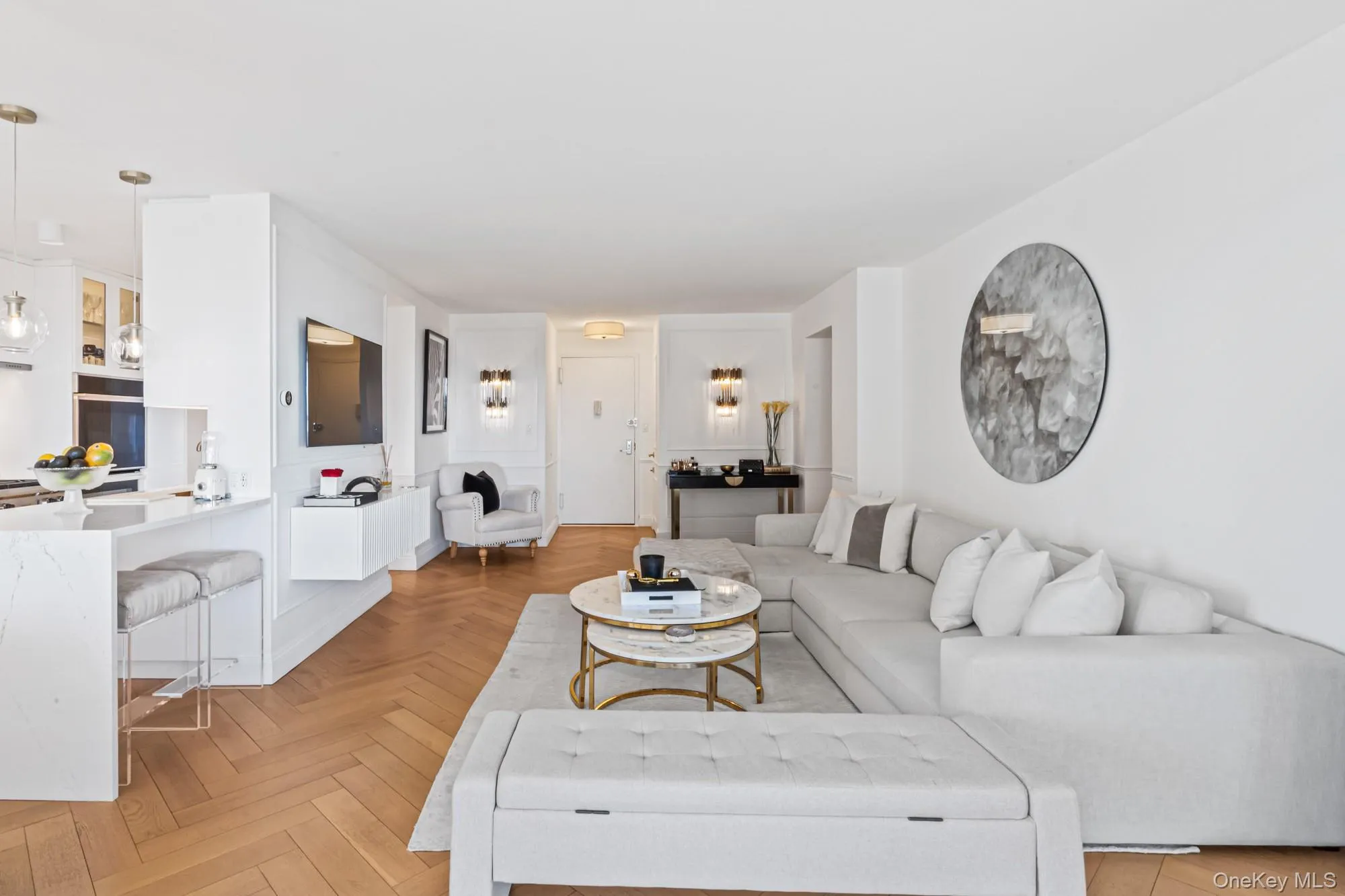 Livingroom featuring herringbone parquet flooring, suspended lighting, and a water view Livingroom featuring herringbone parquet flooring, suspended lighting, and a water view