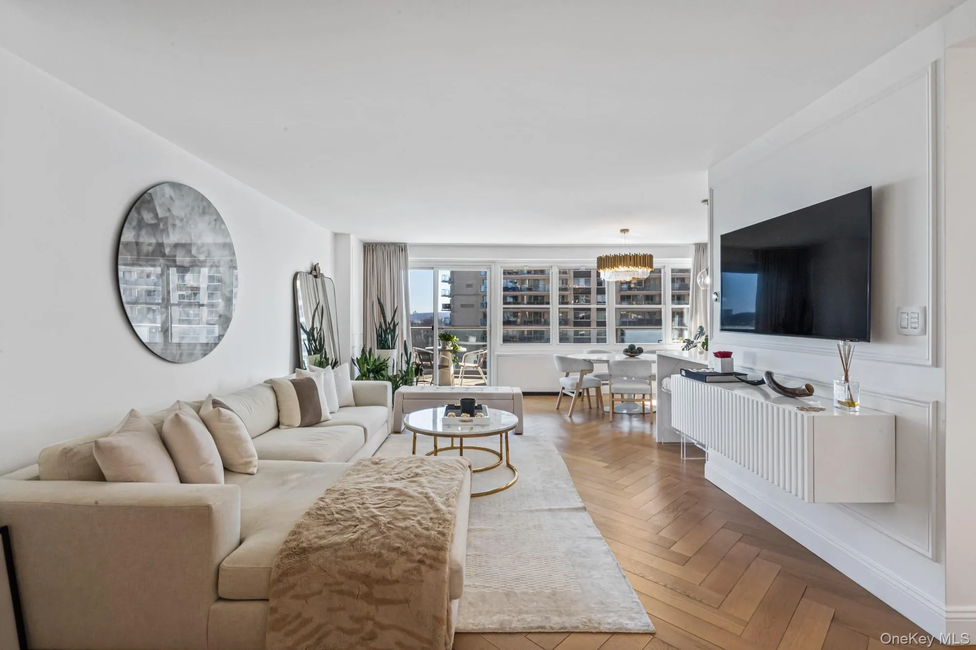 Livingroom featuring herringbone parquet flooring, suspended lighting, and a water view Livingroom featuring herringbone parquet flooring, suspended lighting, and a water view