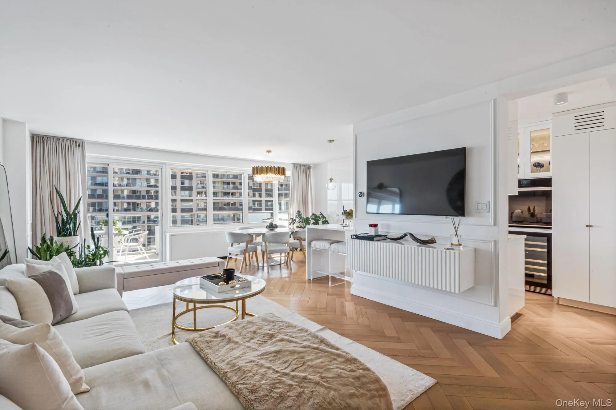 Livingroom featuring herringbone parquet flooring, suspended lighting, and a water view Livingroom featuring herringbone parquet flooring, suspended lighting, and a water view