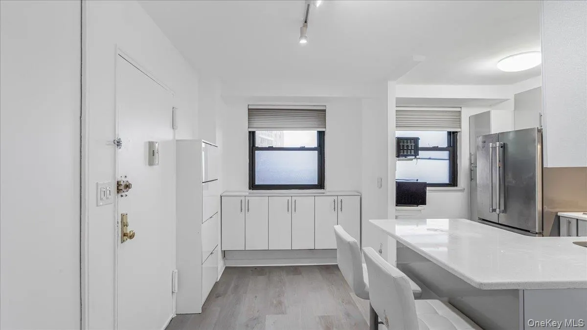 Bathroom featuring light wood-style flooring, a tub to relax in, plenty of natural light, track lighting, and vanity Bathroom featuring light wood-style flooring, a tub to relax in, plenty of natural light, track lighting, and vanity