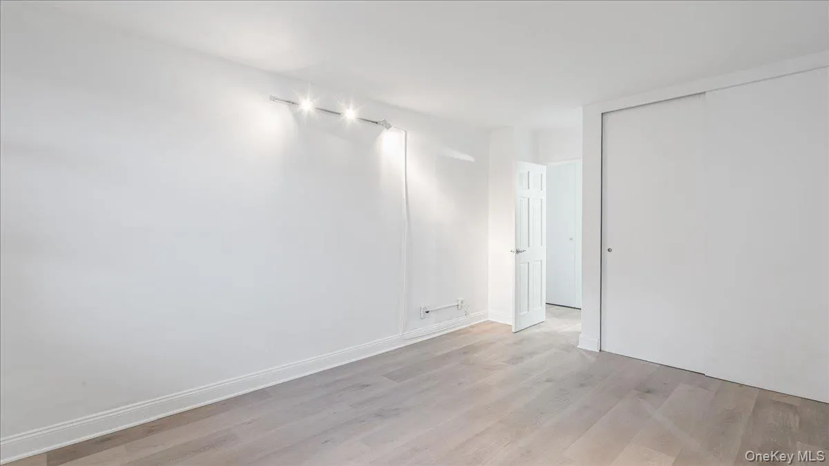 Empty room with light wood finished floors and baseboards Empty room with light wood finished floors and baseboards