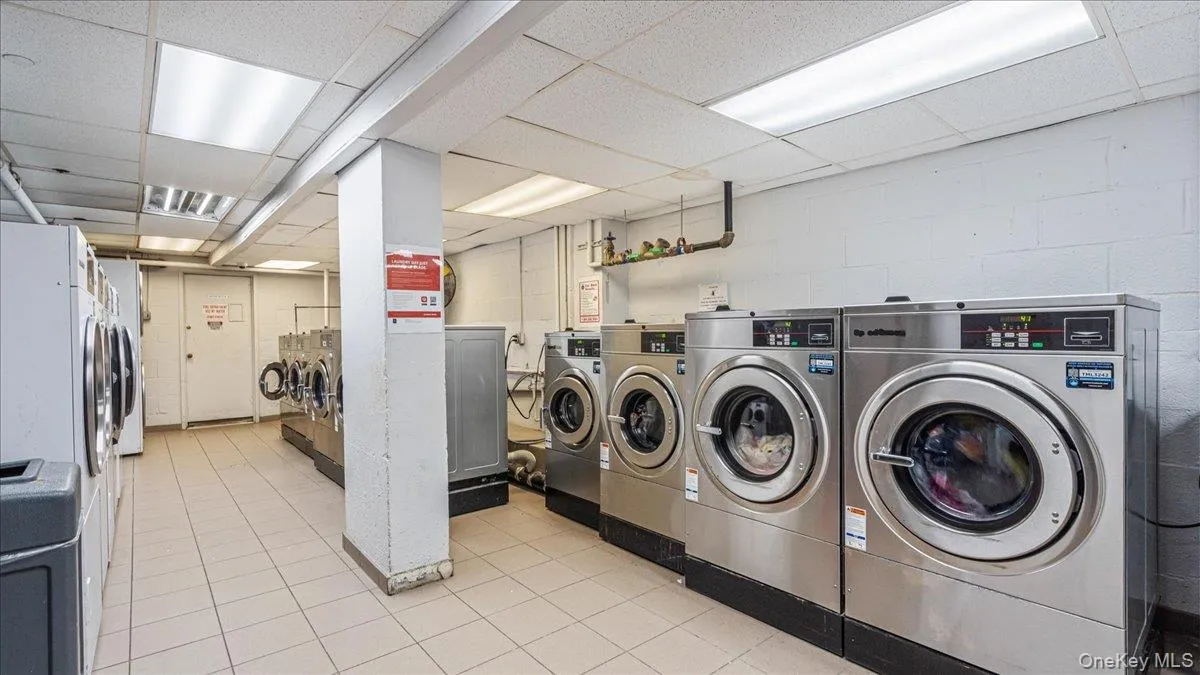 Shared laundry room with a drop ceiling and separate washer and dryer Shared laundry room with a drop ceiling and separate washer and dryer