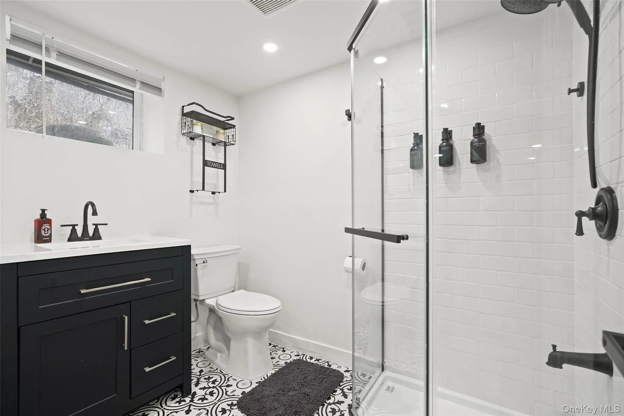 Bathroom featuring vanity, a stall shower, light tile patterned floors, and recessed lighting Bathroom featuring vanity, a stall shower, light tile patterned floors, and recessed lighting