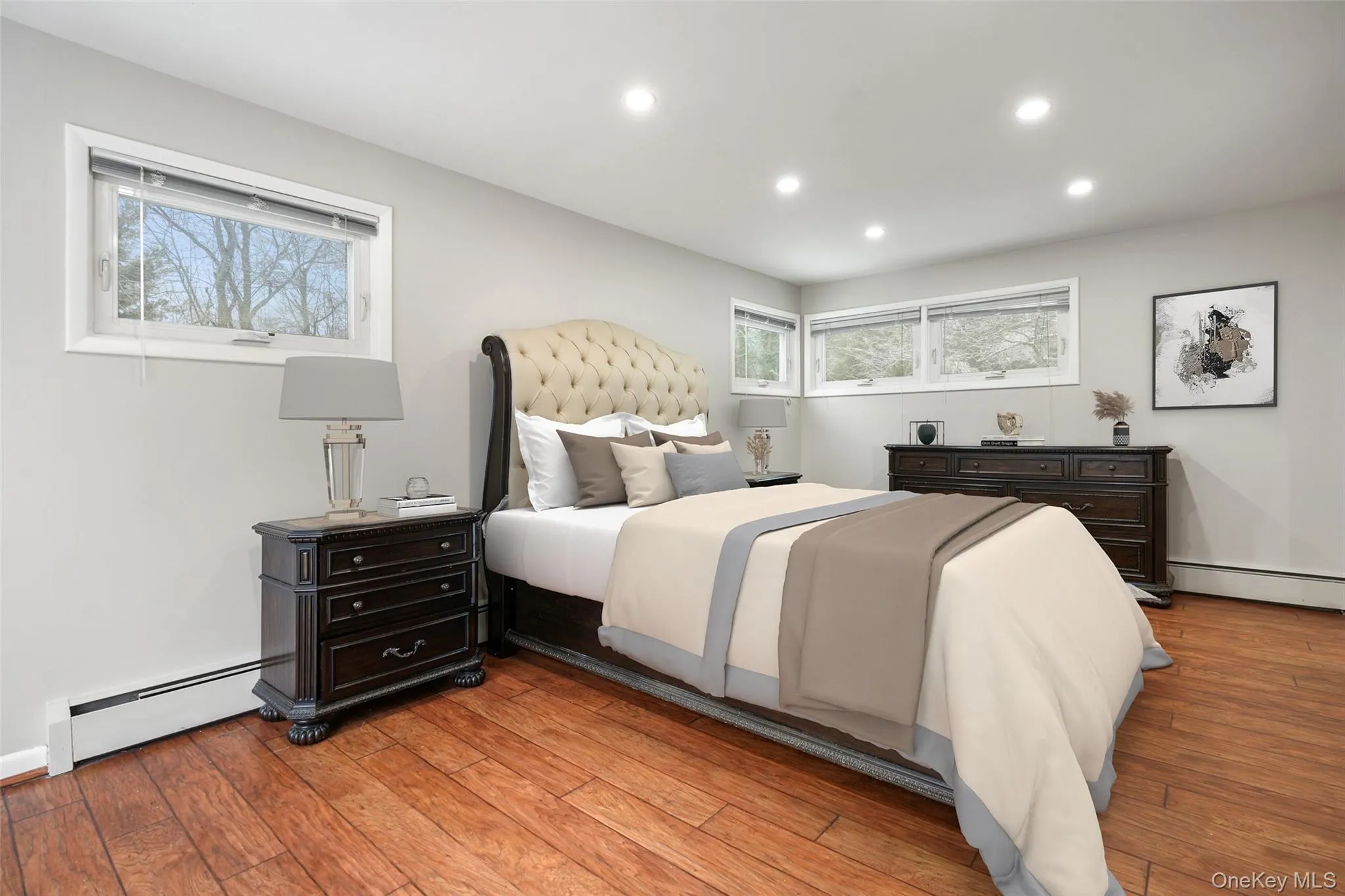 Bedroom with baseboard heating, light wood-style flooring, and recessed lighting. *Virtually Staged* Bedroom with baseboard heating, light wood-style flooring, and recessed lighting. *Virtually Staged*