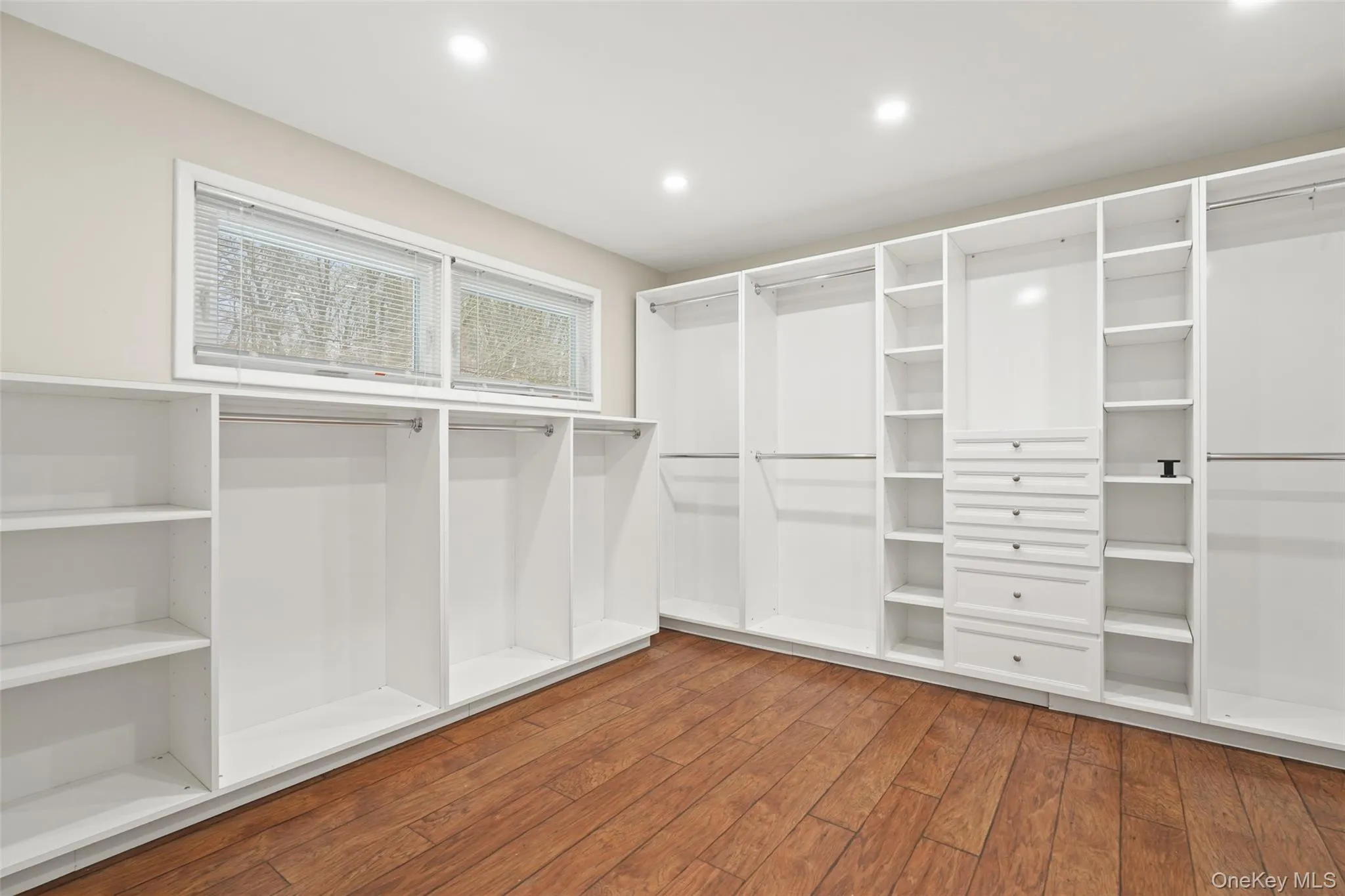 Walk in closet featuring hardwood / wood-style floors Walk in closet featuring hardwood / wood-style floors
