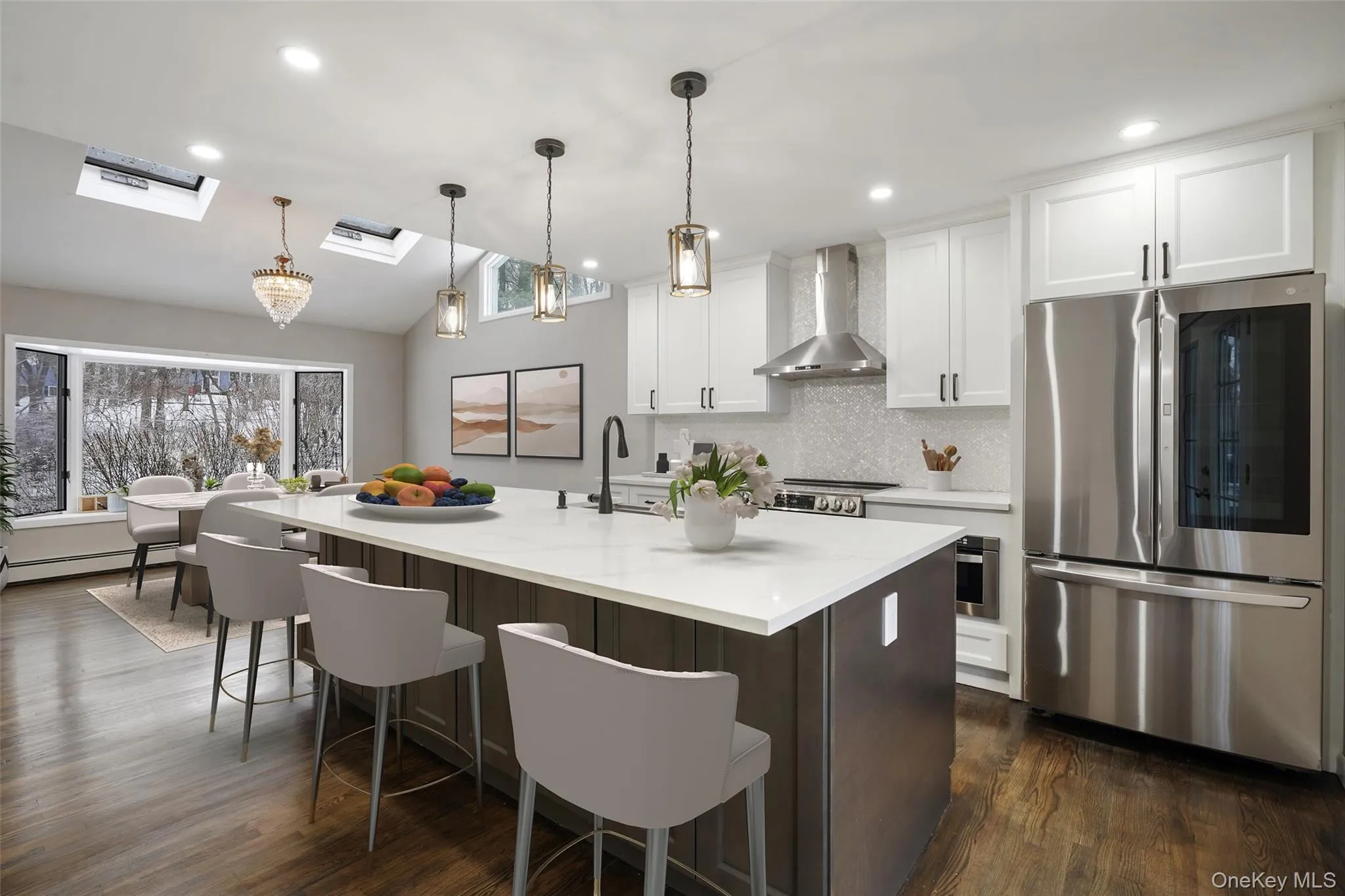Two tone kitchen with stainless steel appliances, lofted ceiling, a breakfast bar, a kitchen island with sink, and two tone cabinets. *Virtually Staged* Two tone kitchen with stainless steel appliances, lofted ceiling, a breakfast bar, a kitchen island with sink, and two tone cabinets. *Virtually Staged*