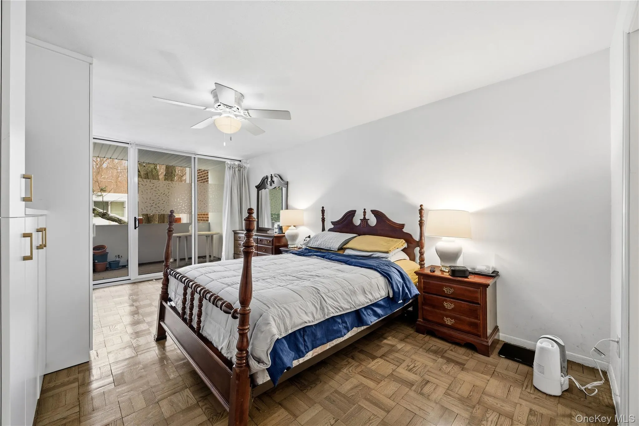 Bedroom featuring parquet floors, access to outside, a ceiling fan, and expansive windows Bedroom featuring parquet floors, access to outside, a ceiling fan, and expansive windows