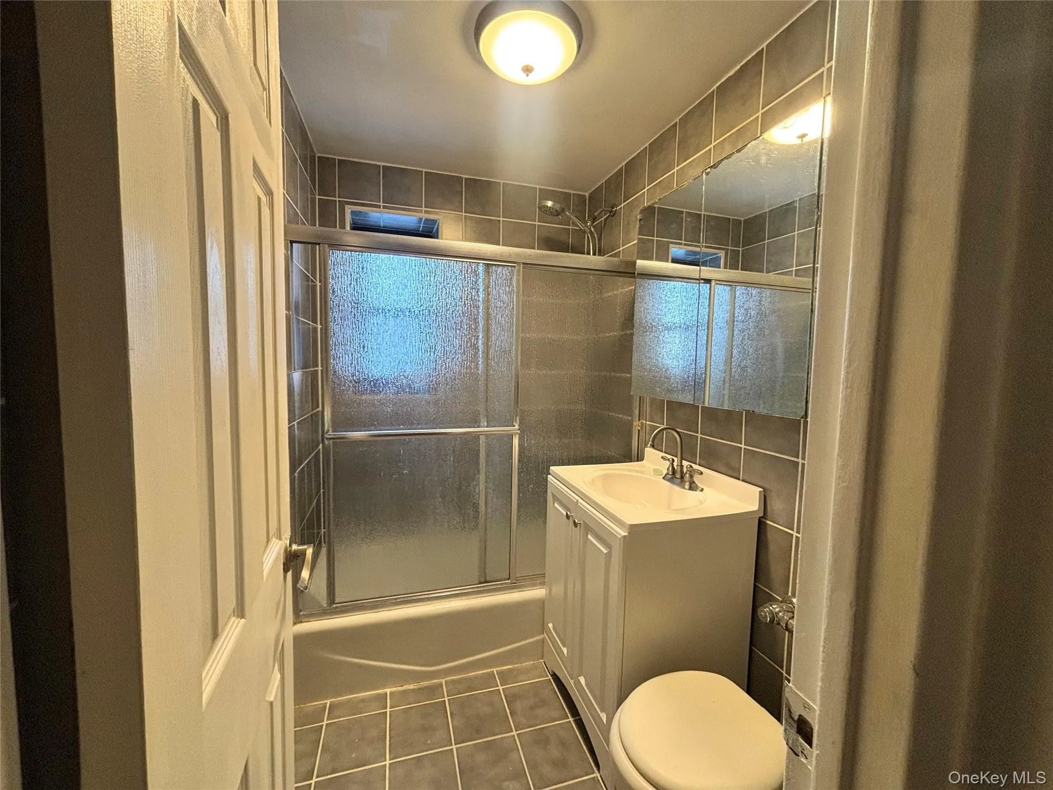 Bathroom with new vanity and floor to ceiling ceramic tiles. Bathroom with new vanity and floor to ceiling ceramic tiles.