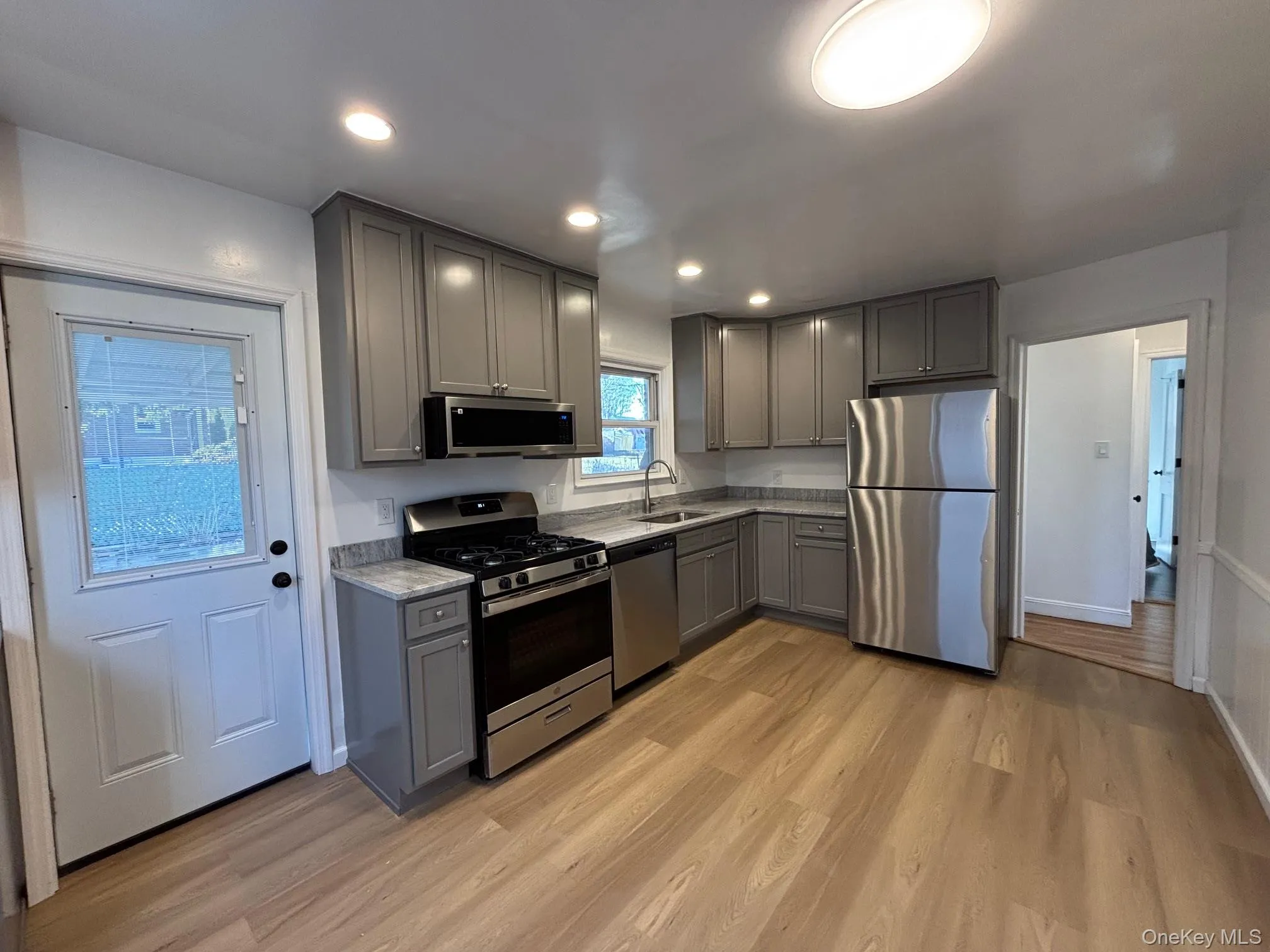 Completely renovated kitchen. New floor, cabinetry, and appliances. Door to backyard. Completely renovated kitchen. New floor, cabinetry, and appliances. Door to backyard.