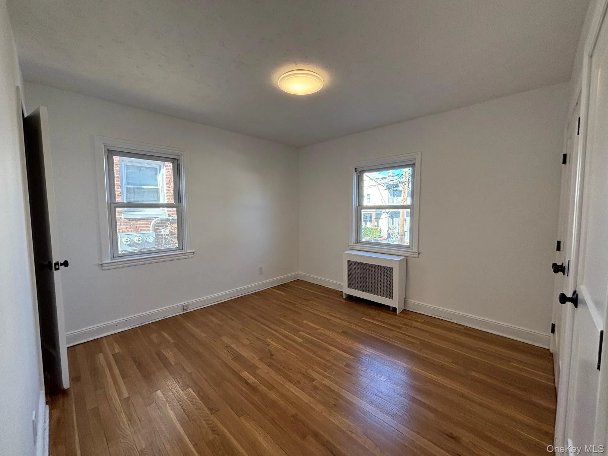 Primary bedroom with ample closet space and refinished wood floor. Primary bedroom with ample closet space and refinished wood floor.