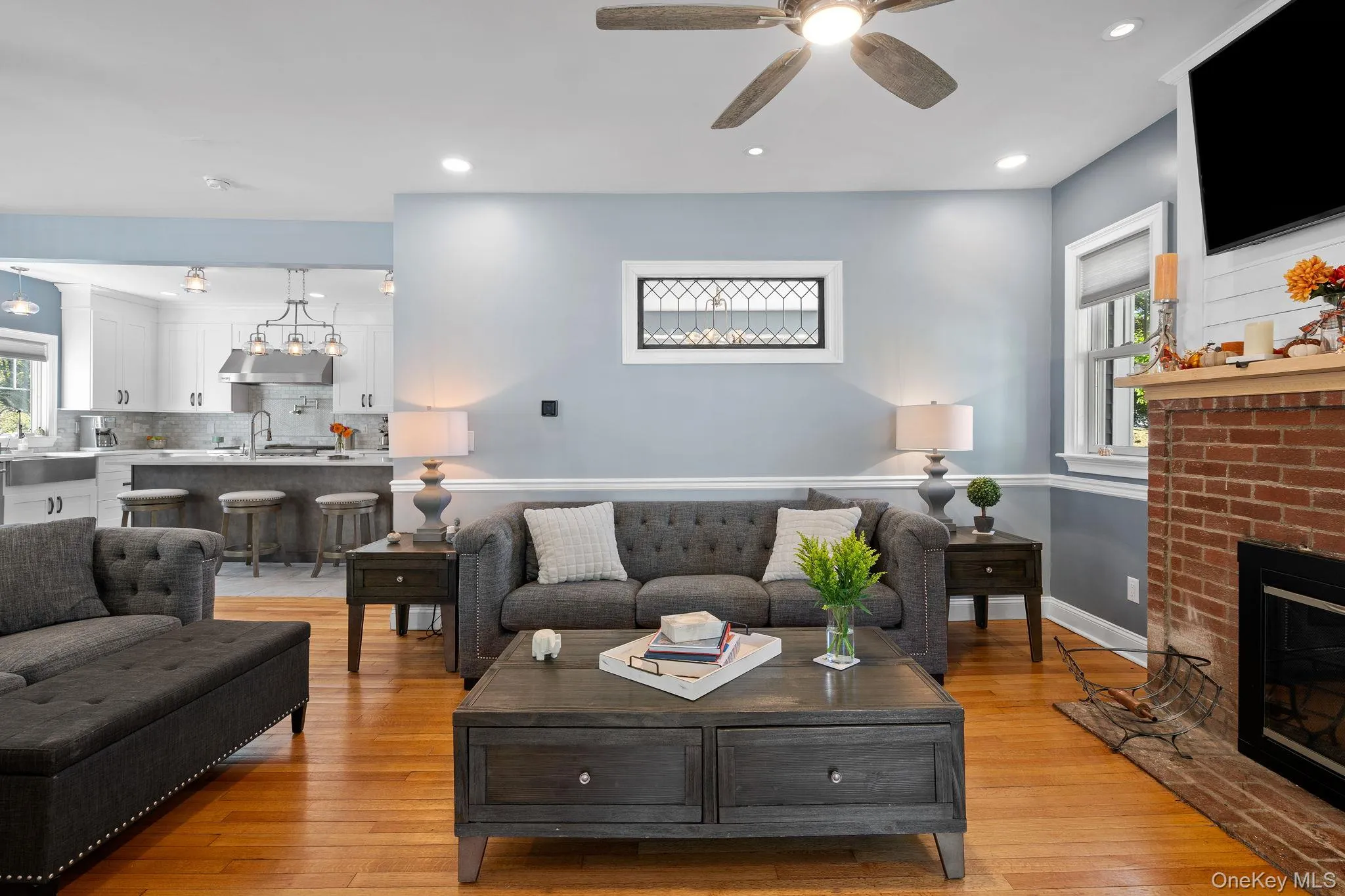 Living area with light wood finished floors, recessed lighting, a fireplace, and ceiling fan Living area with light wood finished floors, recessed lighting, a fireplace, and ceiling fan