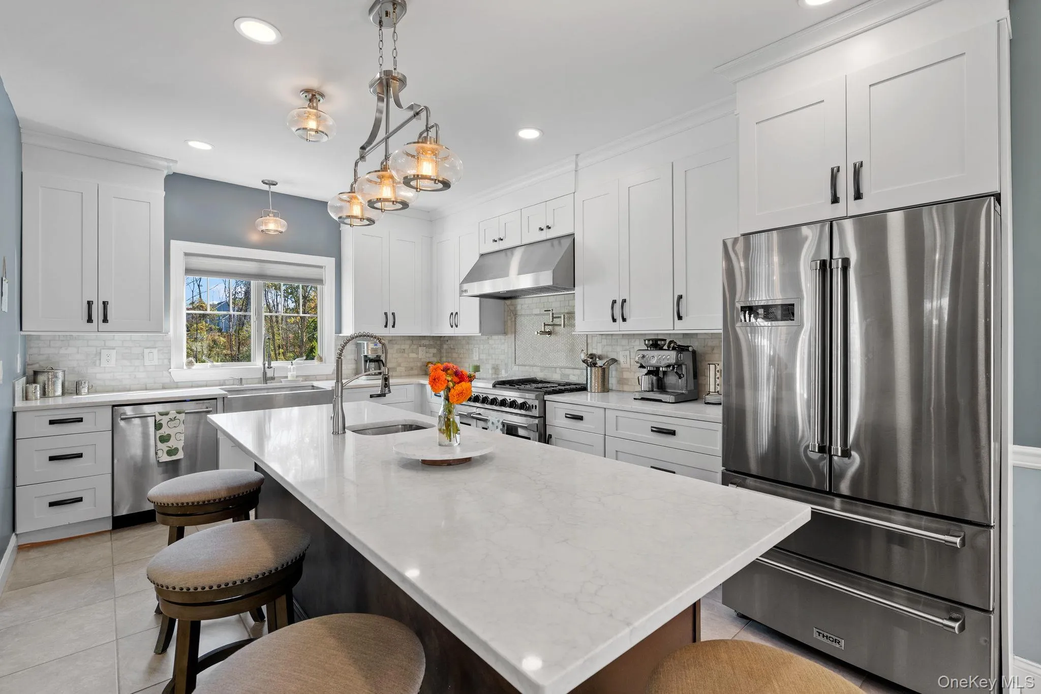 Kitchen with high end appliances, white cabinets, a breakfast bar area, recessed lighting, and crown molding Kitchen with high end appliances, white cabinets, a breakfast bar area, recessed lighting, and crown molding