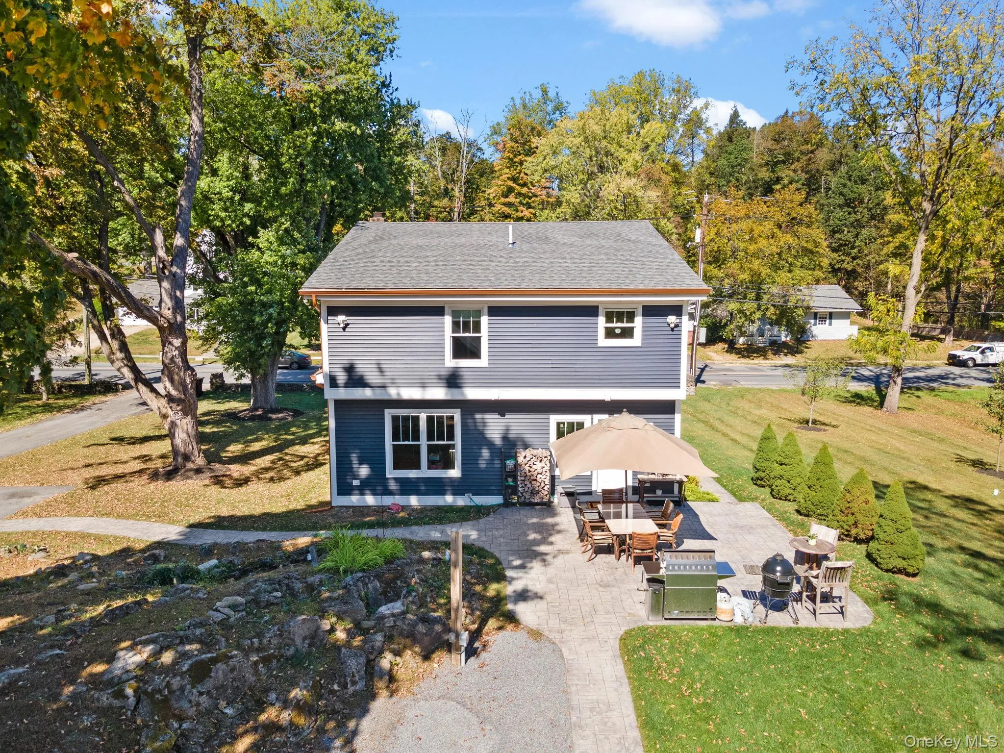 Rear view of property with a patio, a lawn, and a shingled roof Rear view of property with a patio, a lawn, and a shingled roof