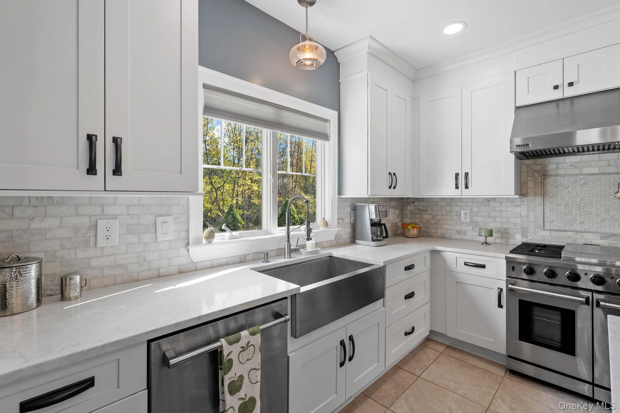 Kitchen with stainless steel appliances, under cabinet range hood, light stone countertops, white cabinetry, and recessed lighting Kitchen with stainless steel appliances, under cabinet range hood, light stone countertops, white cabinetry, and recessed lighting