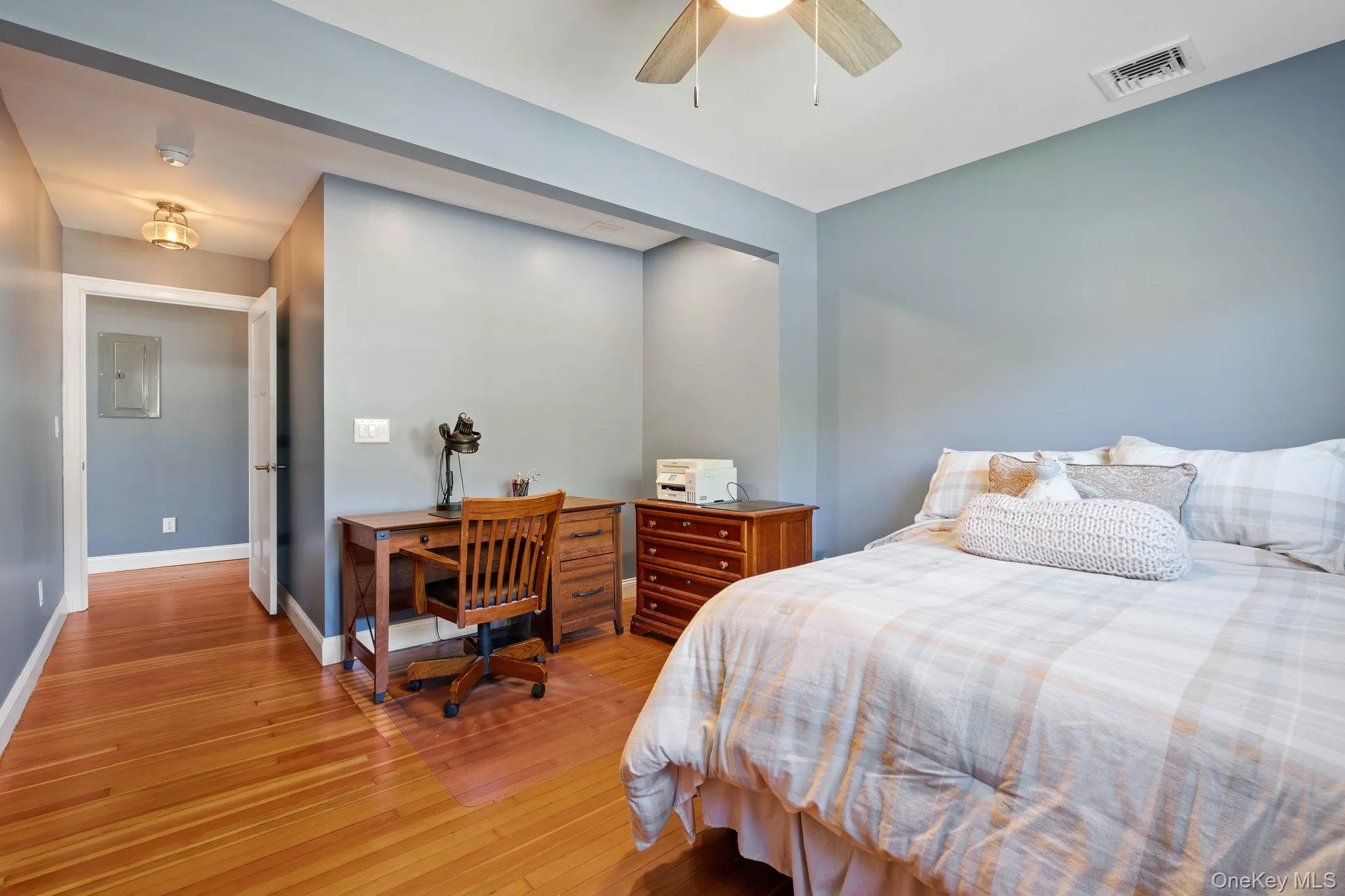 Bedroom featuring wood finished floors, electric panel, and a ceiling fan Bedroom featuring wood finished floors, electric panel, and a ceiling fan