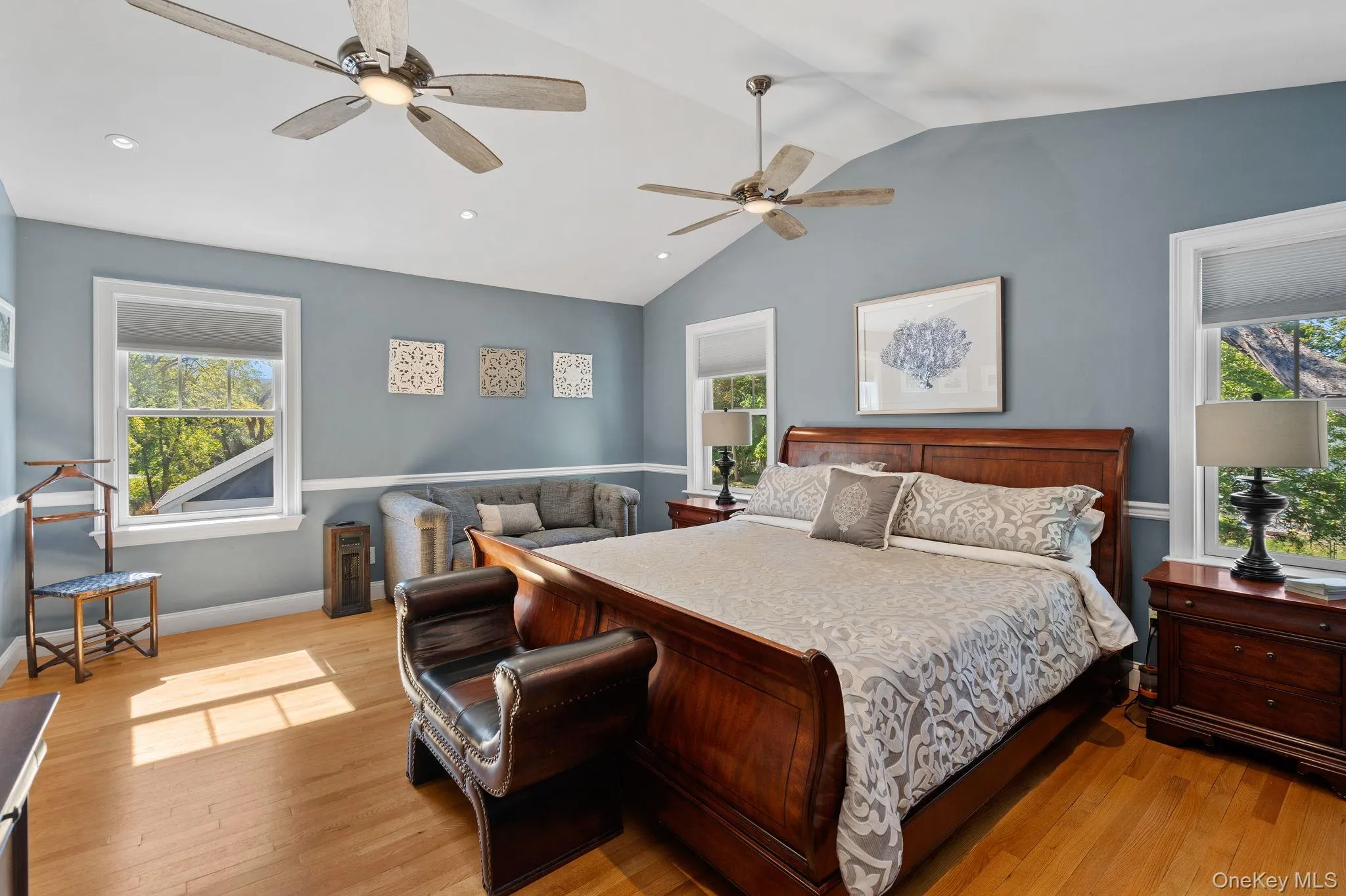 Bedroom with multiple windows, lofted ceiling, light wood-type flooring, recessed lighting, and a ceiling fan Bedroom with multiple windows, lofted ceiling, light wood-type flooring, recessed lighting, and a ceiling fan
