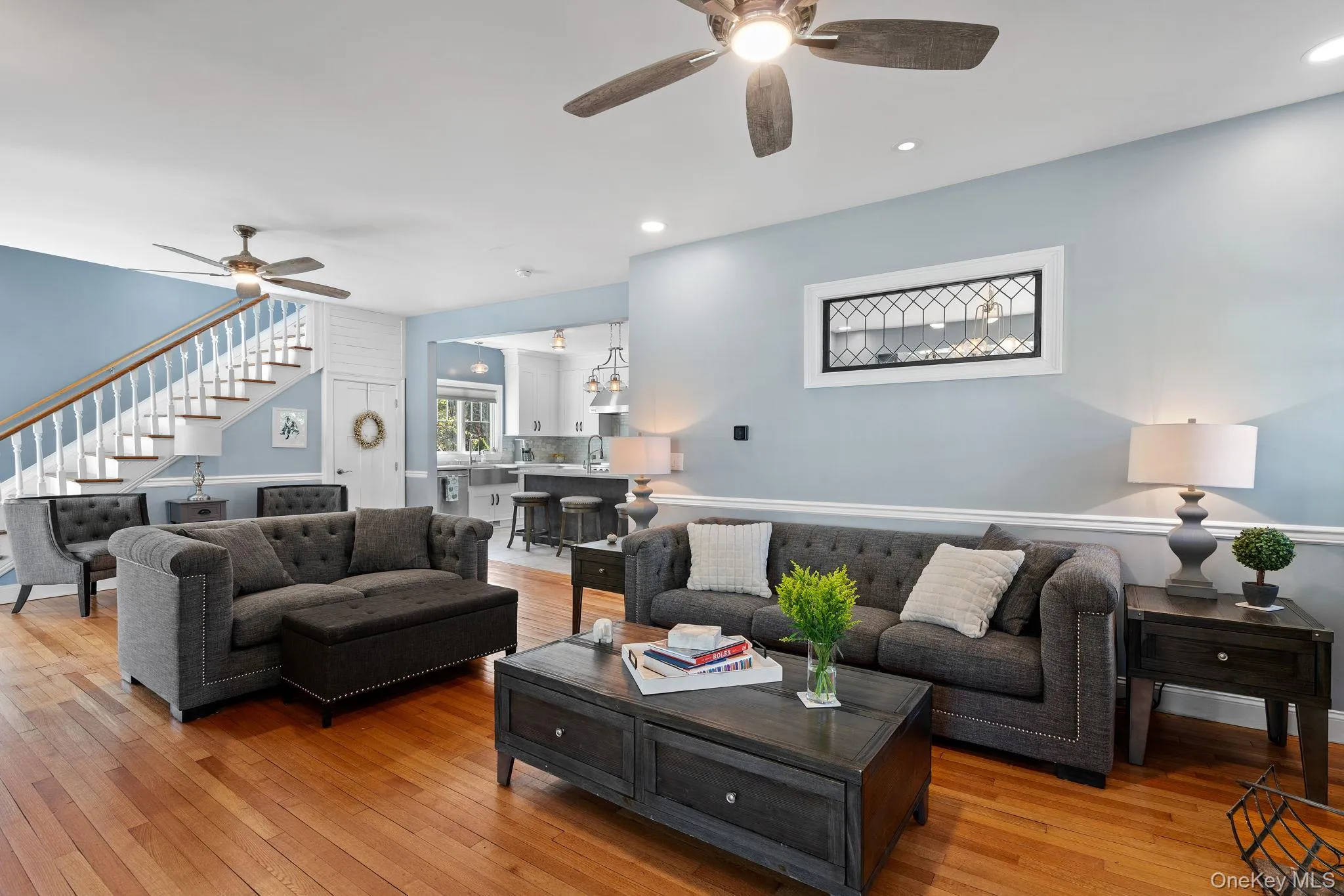 Living area with light wood finished floors, a ceiling fan, stairs, and recessed lighting Living area with light wood finished floors, a ceiling fan, stairs, and recessed lighting