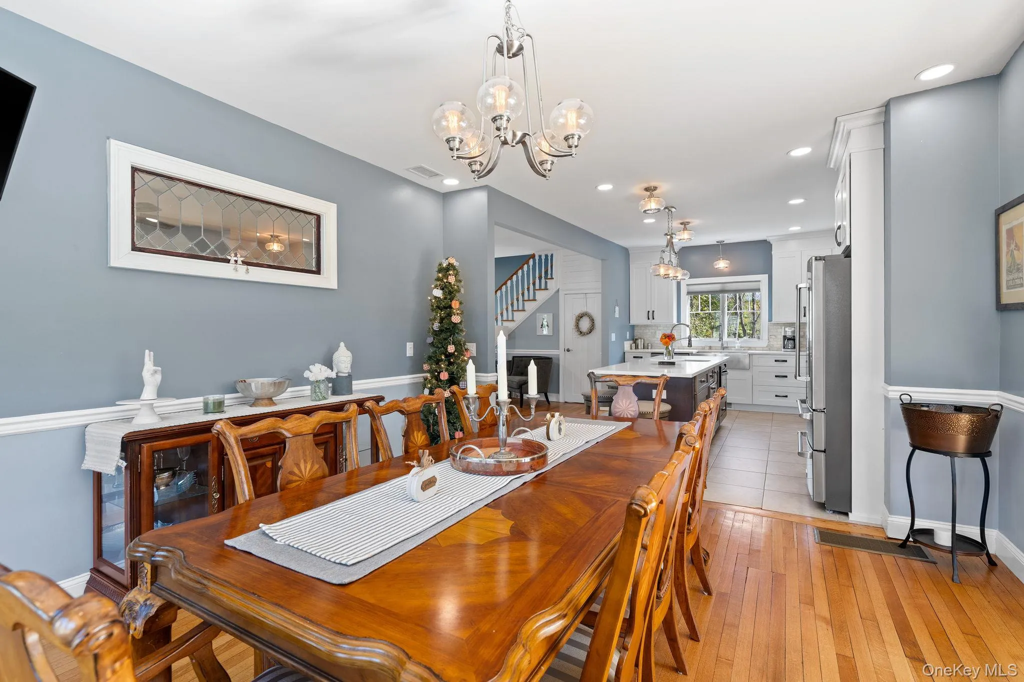 Dining space featuring a chandelier, light wood finished floors, stairs, and recessed lighting Dining space featuring a chandelier, light wood finished floors, stairs, and recessed lighting