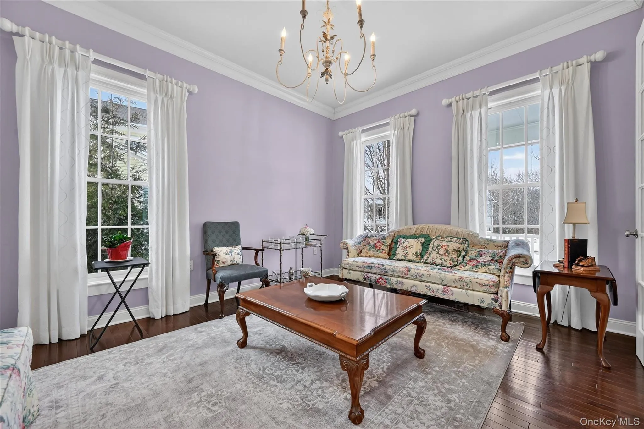 Sunlit sitting room framed by large windows and soft natural light. Sunlit sitting room framed by large windows and soft natural light.