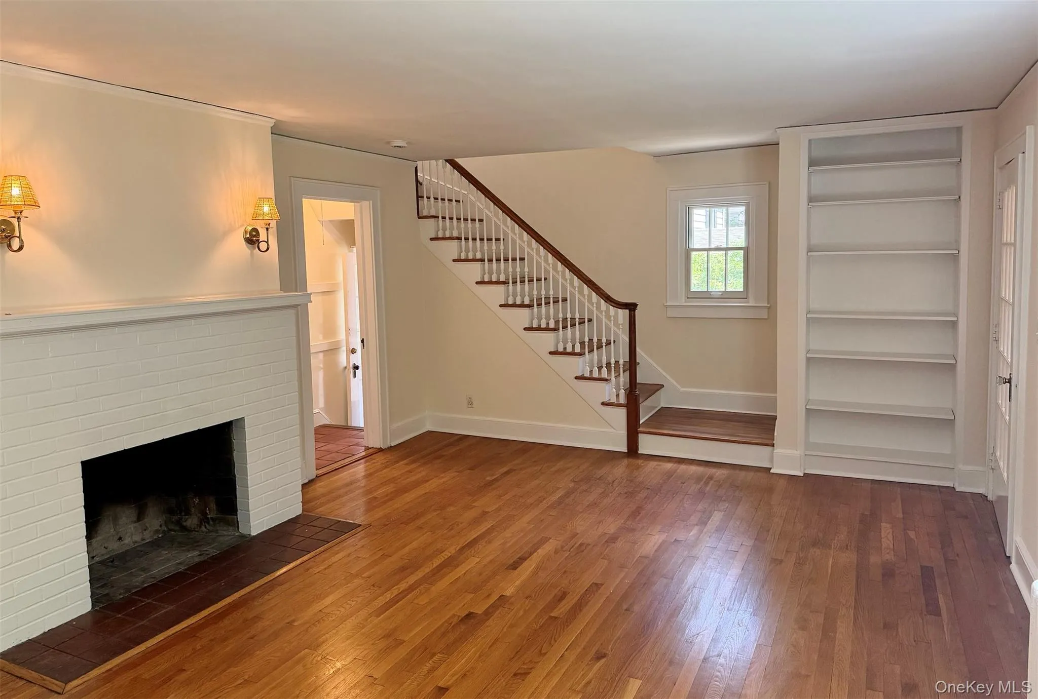 Living room with fireplace, hardwood floors and stairs to second floor Living room with fireplace, hardwood floors and stairs to second floor
