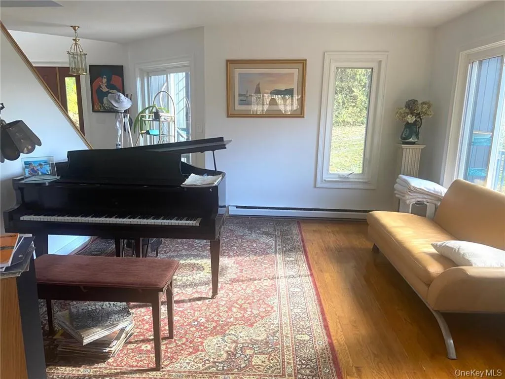 Living area with a baseboard heating unit and hardwood / wood-style floors Living area with a baseboard heating unit and hardwood / wood-style floors