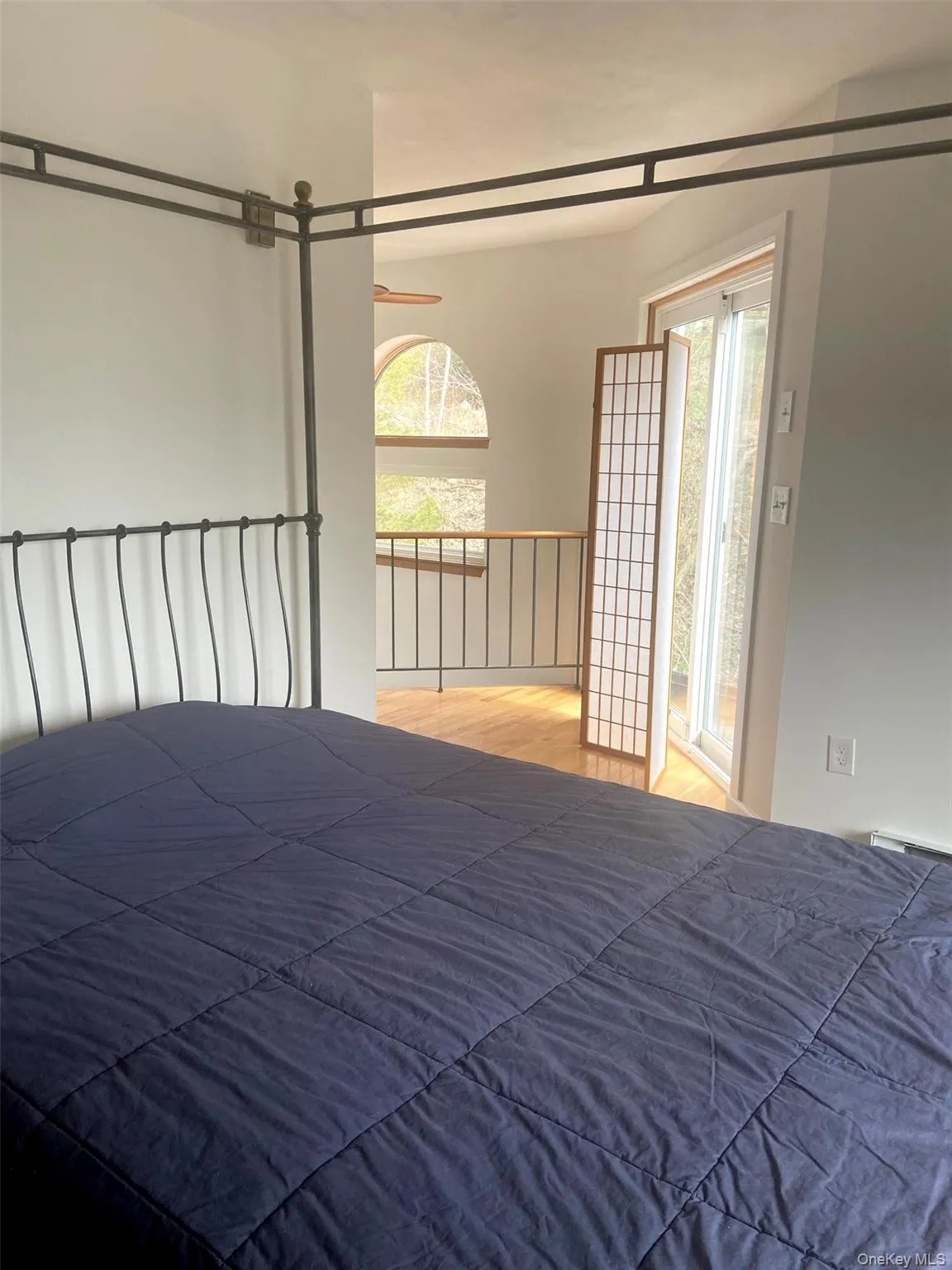 Bedroom featuring multiple windows and wood finished floors Bedroom featuring multiple windows and wood finished floors