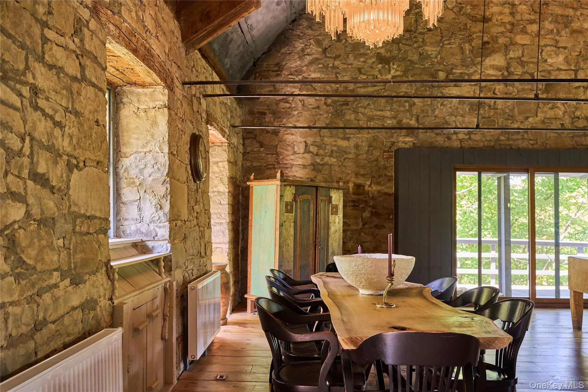 Dining space featuring radiator, hardwood / wood-style floors, a high ceiling, and a chandelier Dining space featuring radiator, hardwood / wood-style floors, a high ceiling, and a chandelier