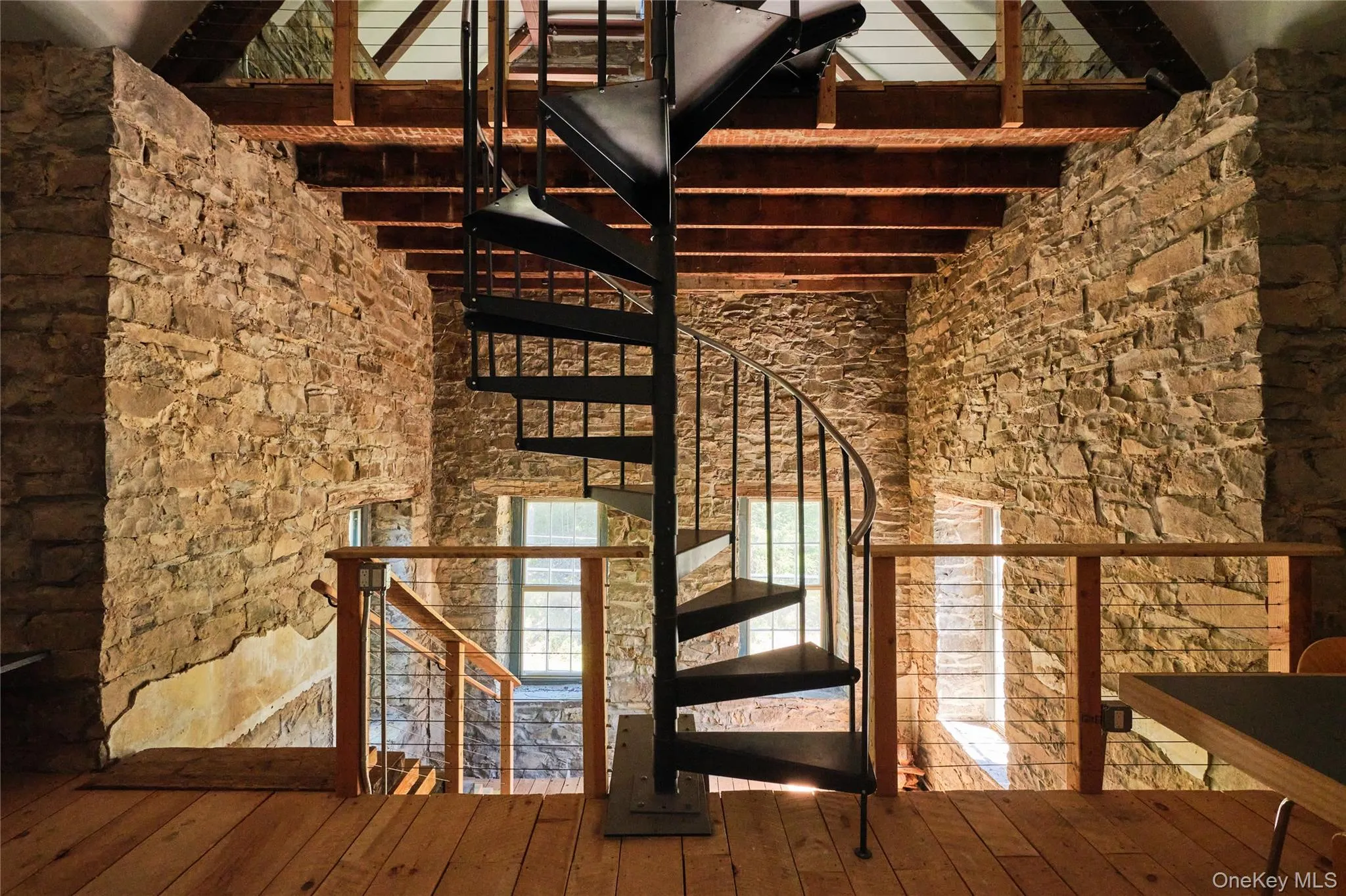 Staircase featuring beamed ceiling, a towering ceiling, and wood-type flooring Staircase featuring beamed ceiling, a towering ceiling, and wood-type flooring