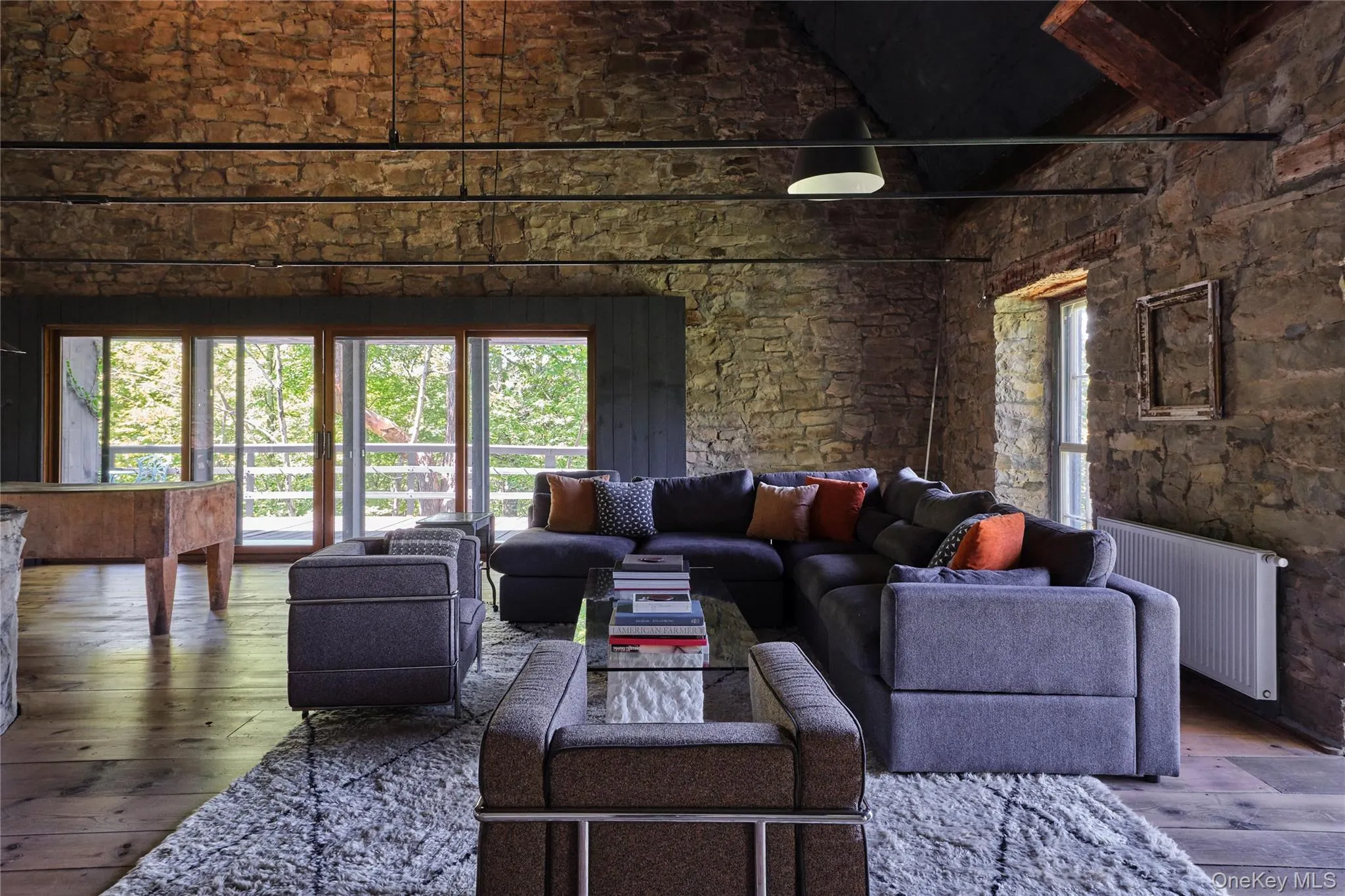 Living room featuring hardwood / wood-style flooring, radiator, high vaulted ceiling, and beamed ceiling Living room featuring hardwood / wood-style flooring, radiator, high vaulted ceiling, and beamed ceiling