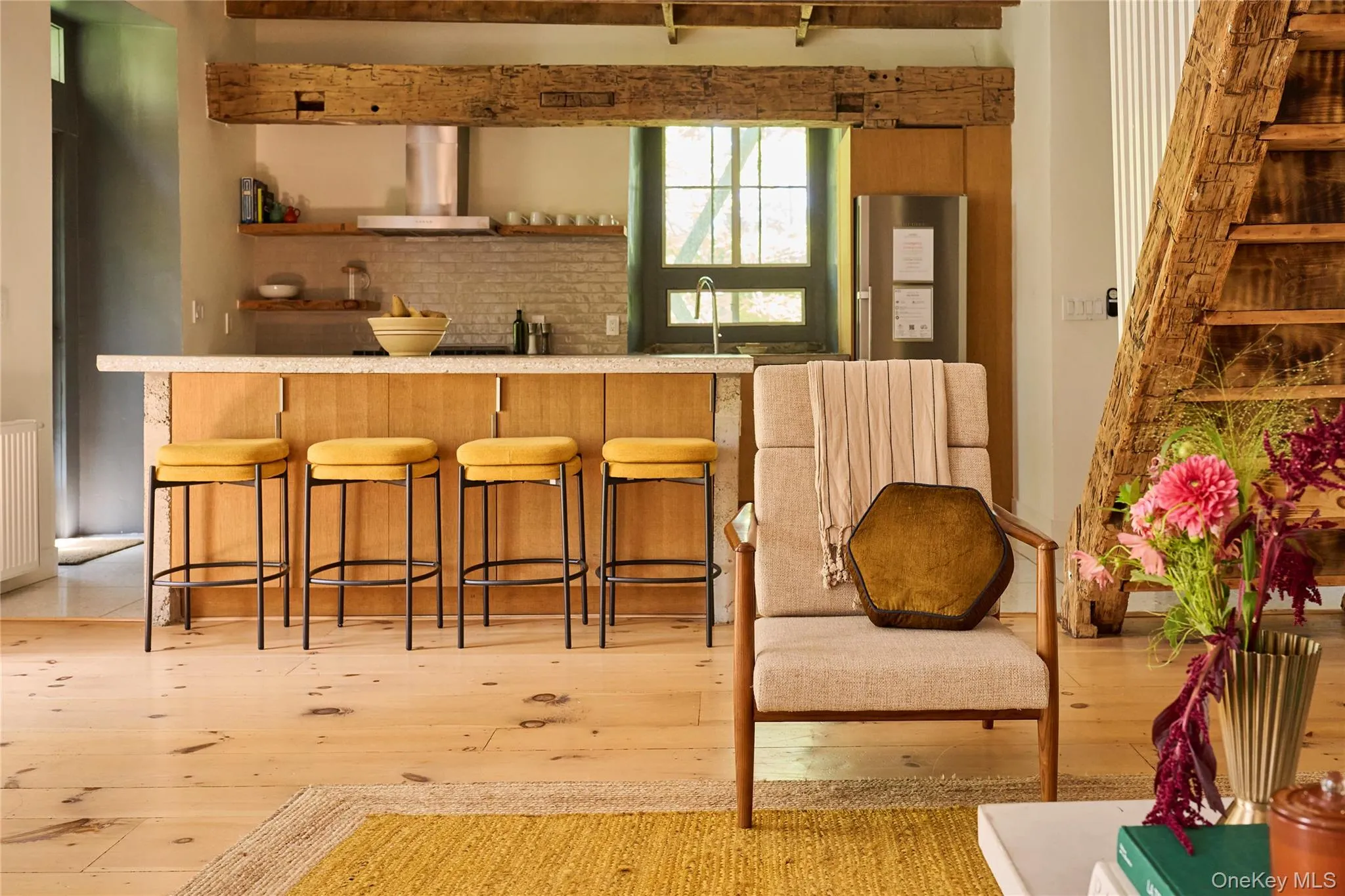 Bar area with open shelves, light countertops, wall chimney range hood, freestanding refrigerator, and light wood-type flooring Bar area with open shelves, light countertops, wall chimney range hood, freestanding refrigerator, and light wood-type flooring