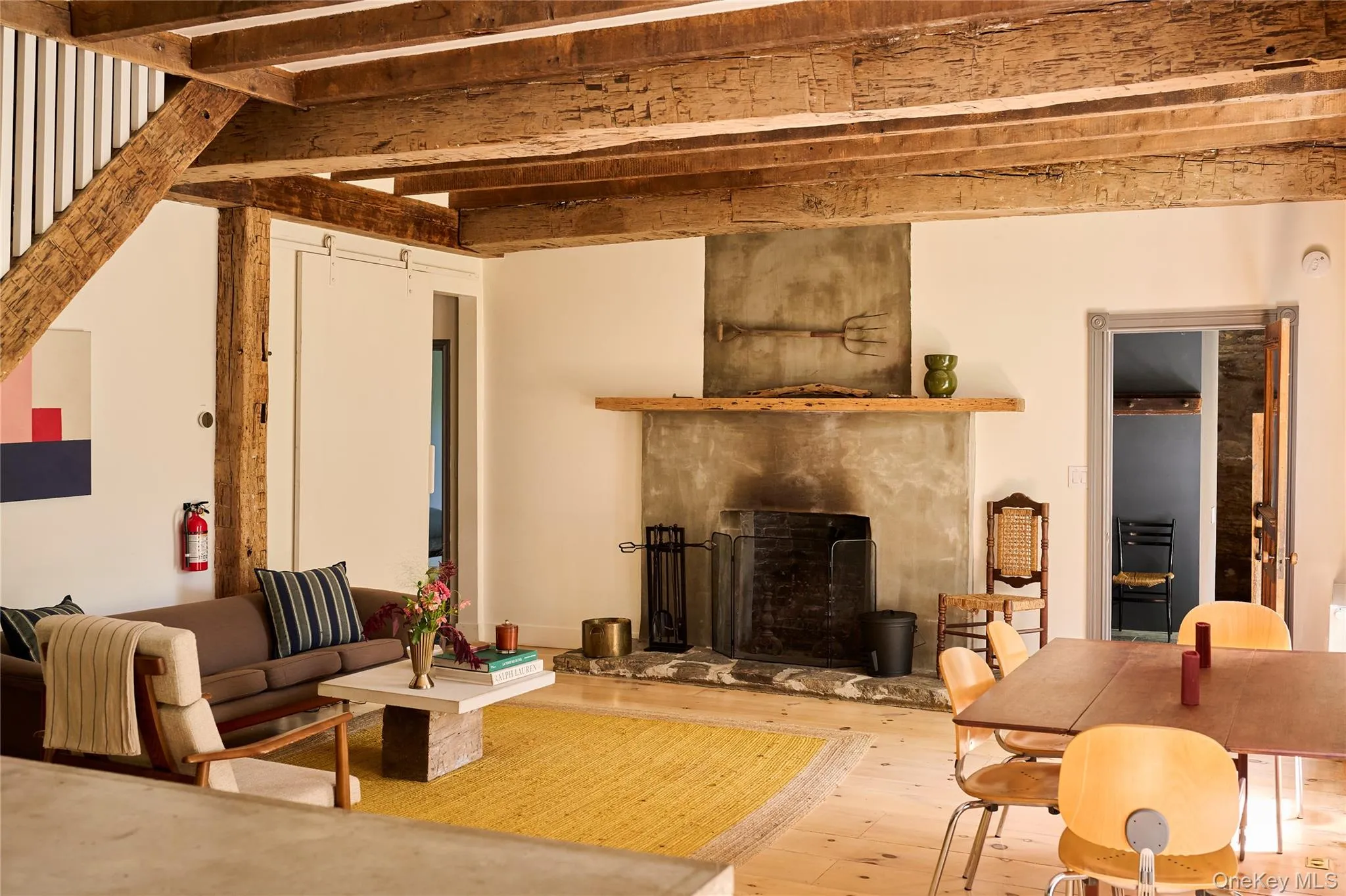 Living room with a premium fireplace, beamed ceiling, and hardwood / wood-style floors Living room with a premium fireplace, beamed ceiling, and hardwood / wood-style floors