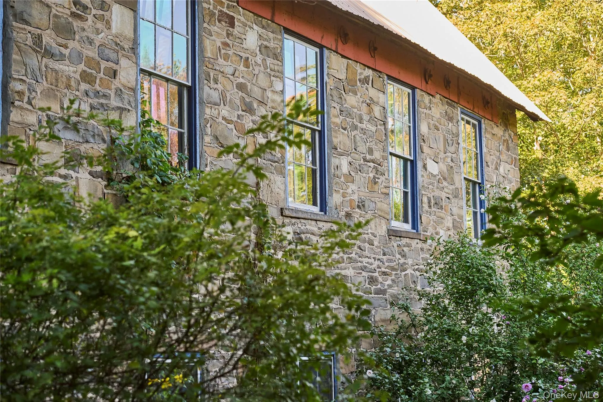 View of home's exterior with stone siding and a metal roof View of home's exterior with stone siding and a metal roof