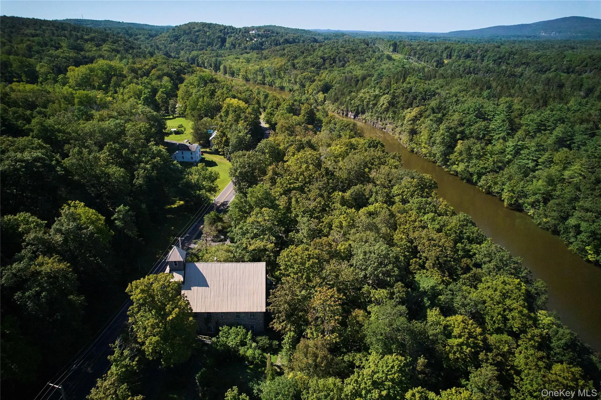 Aerial view of property and surrounding area featuring a forest and a large body of water Aerial view of property and surrounding area featuring a forest and a large body of water