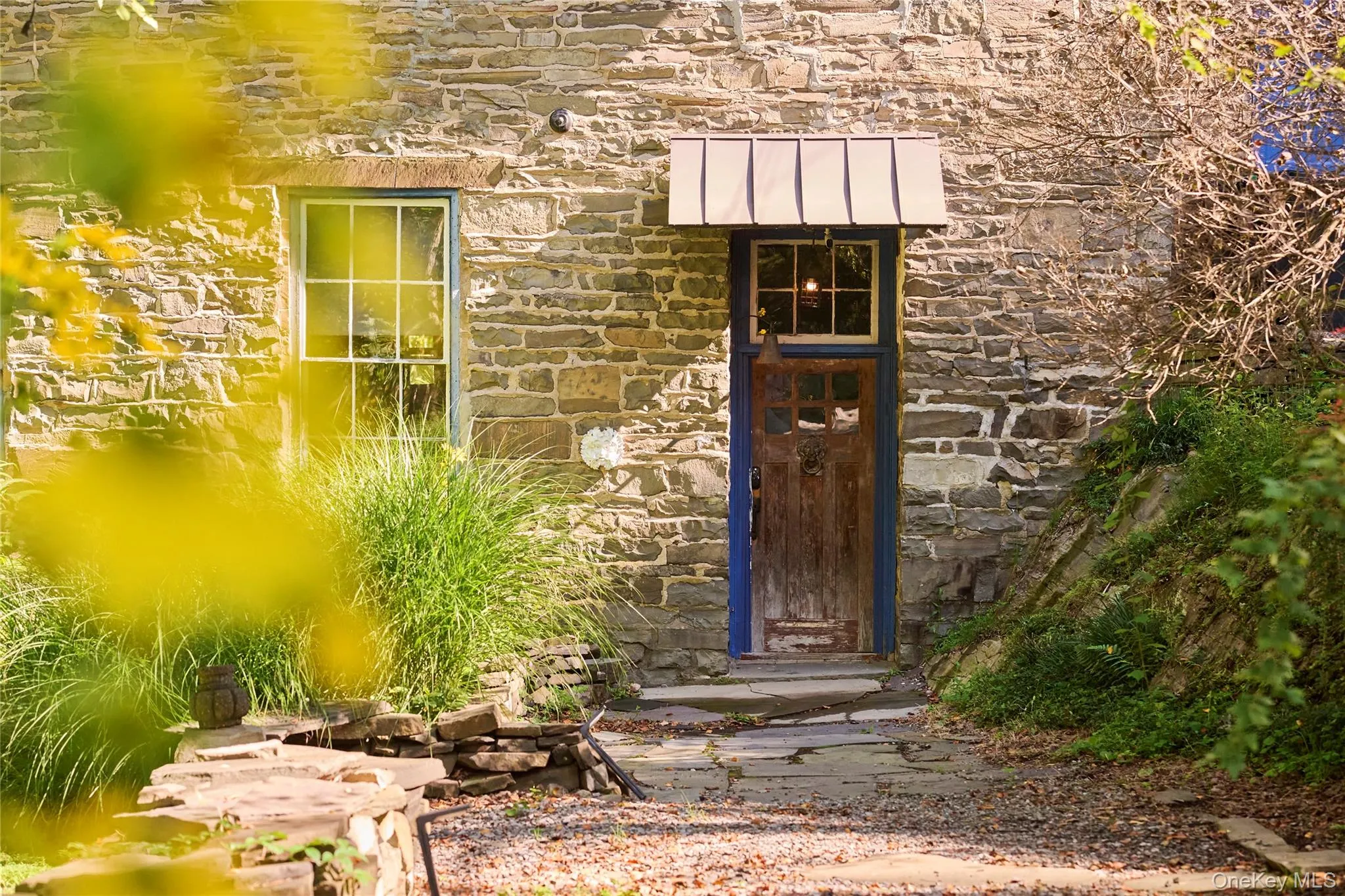 Doorway to property with stone siding, a standing seam roof, and a metal roof Doorway to property with stone siding, a standing seam roof, and a metal roof