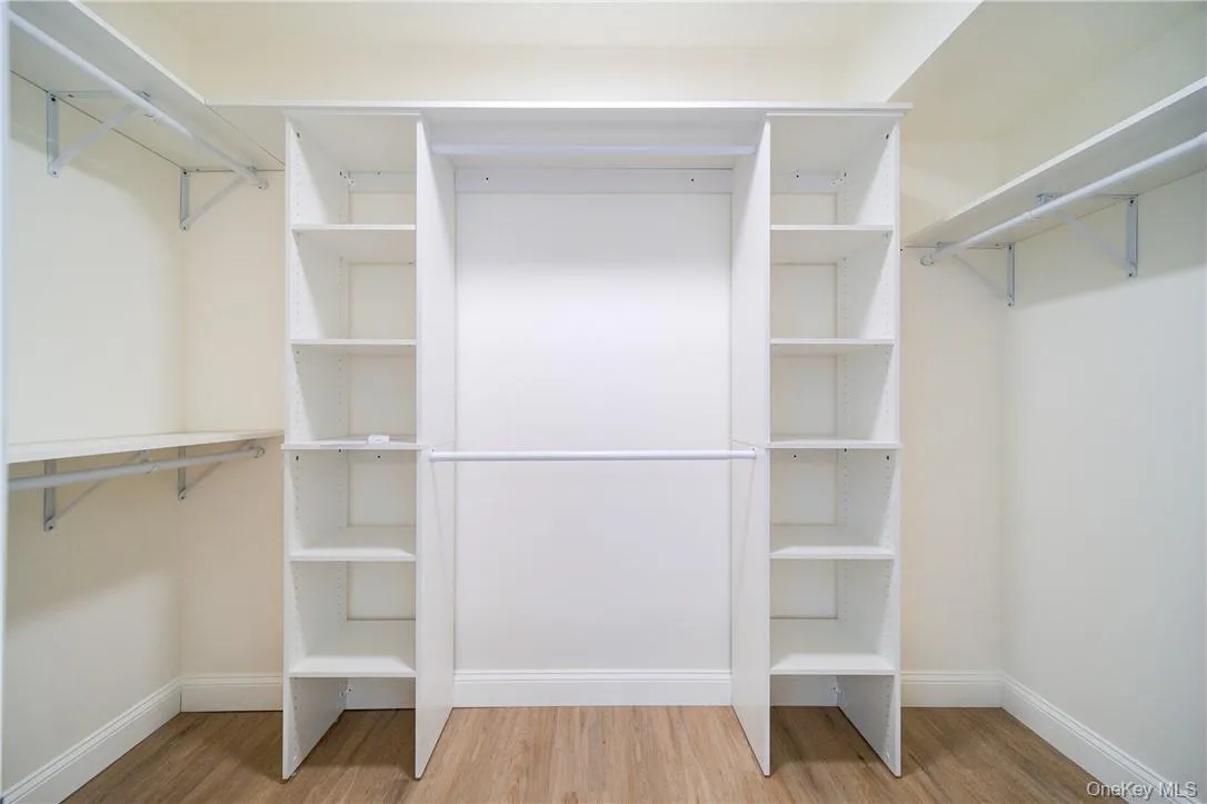Walk in closet featuring light hardwood / wood-style flooring Walk in closet featuring light hardwood / wood-style flooring