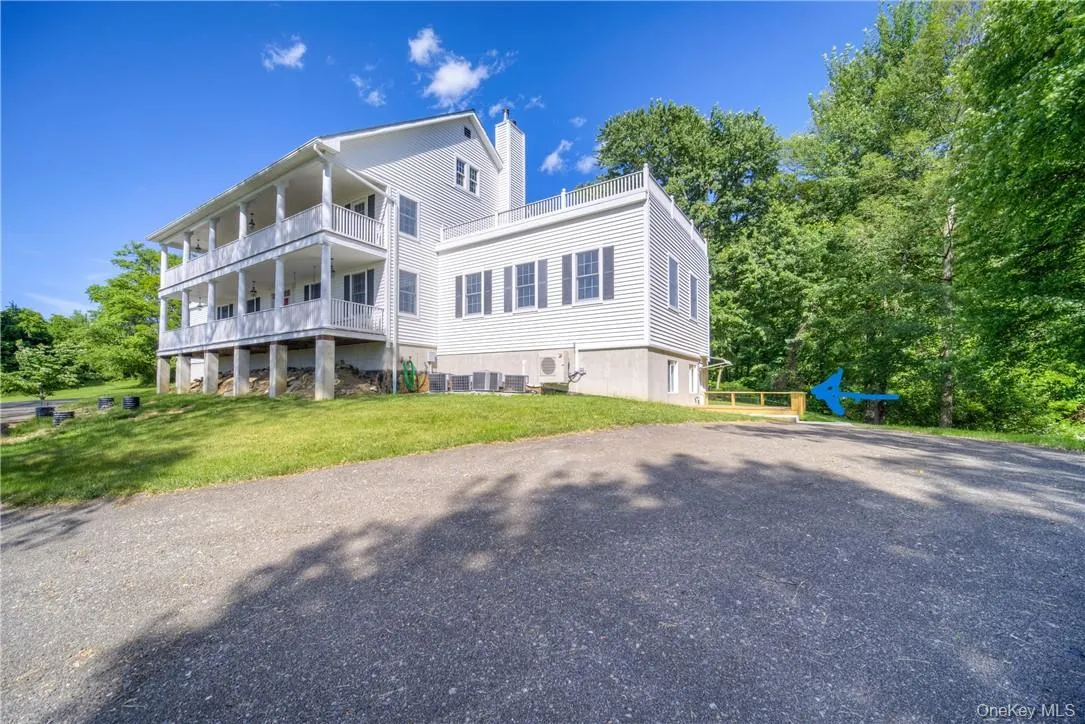 View of front of home with a front lawn and a balcony View of front of home with a front lawn and a balcony
