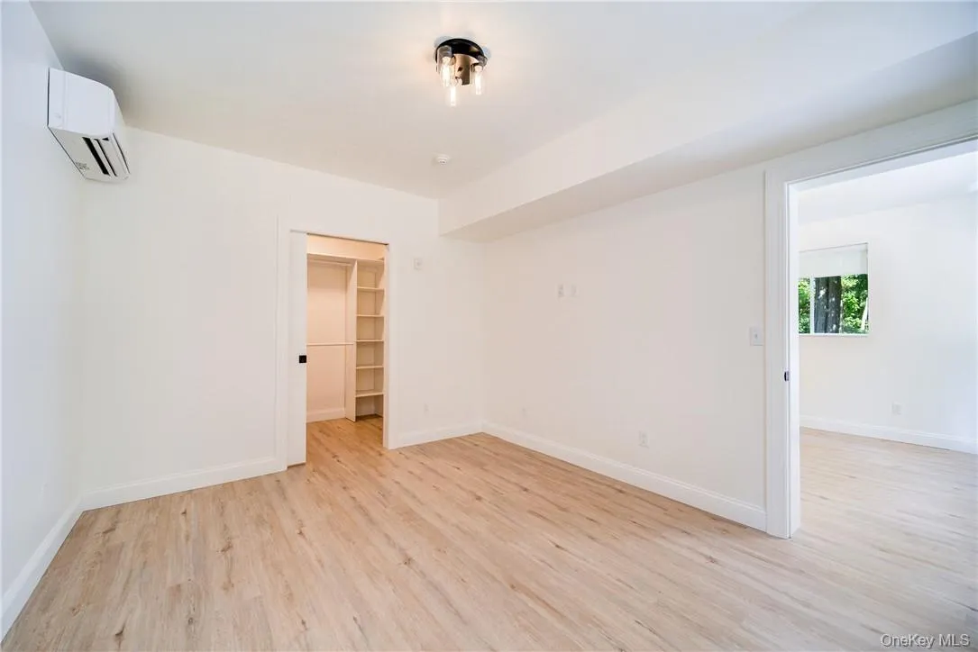 Unfurnished room with a wall mounted AC and light wood-type flooring Unfurnished room with a wall mounted AC and light wood-type flooring