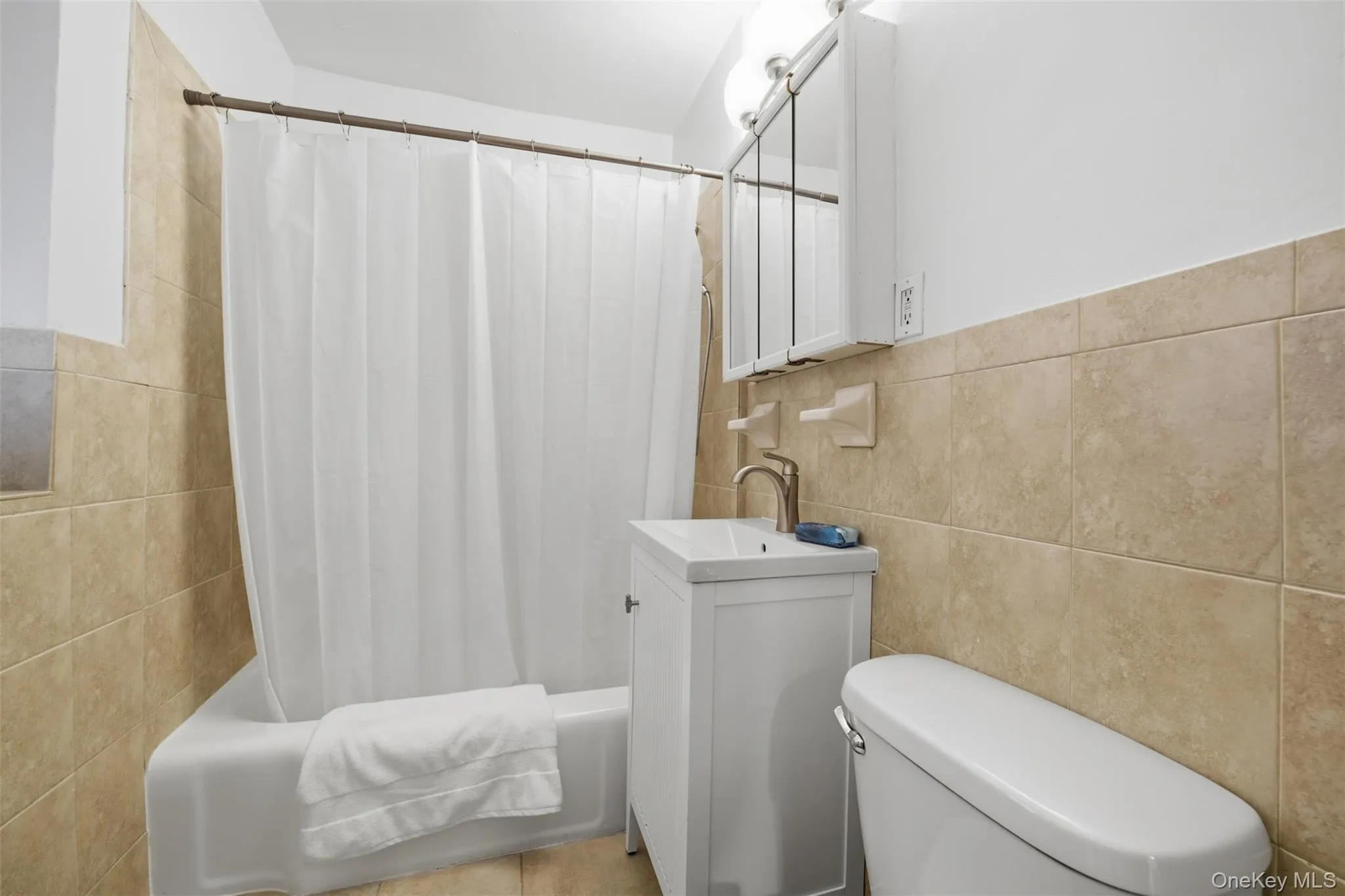 Full hall bathroom featuring tiled walls and a bathtub and shower combination. Full hall bathroom featuring tiled walls and a bathtub and shower combination.