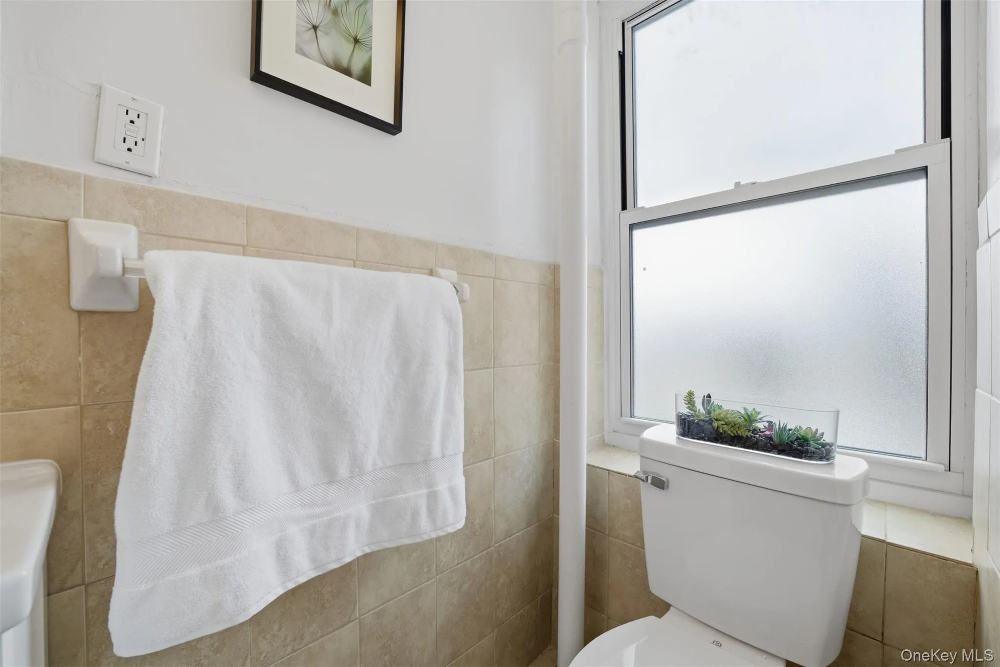 Primary bathroom featuring tiled walls and a stand-in shower. Primary bathroom featuring tiled walls and a stand-in shower.