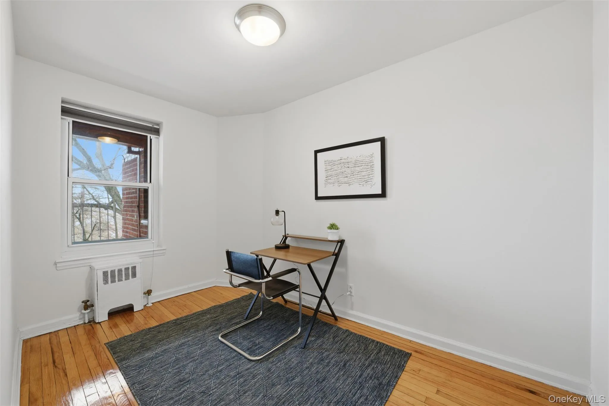 Bedroom with hardwood floors and a window overlooking the Hudson River, offering flexible use options. Bedroom with hardwood floors and a window overlooking the Hudson River, offering flexible use options.
