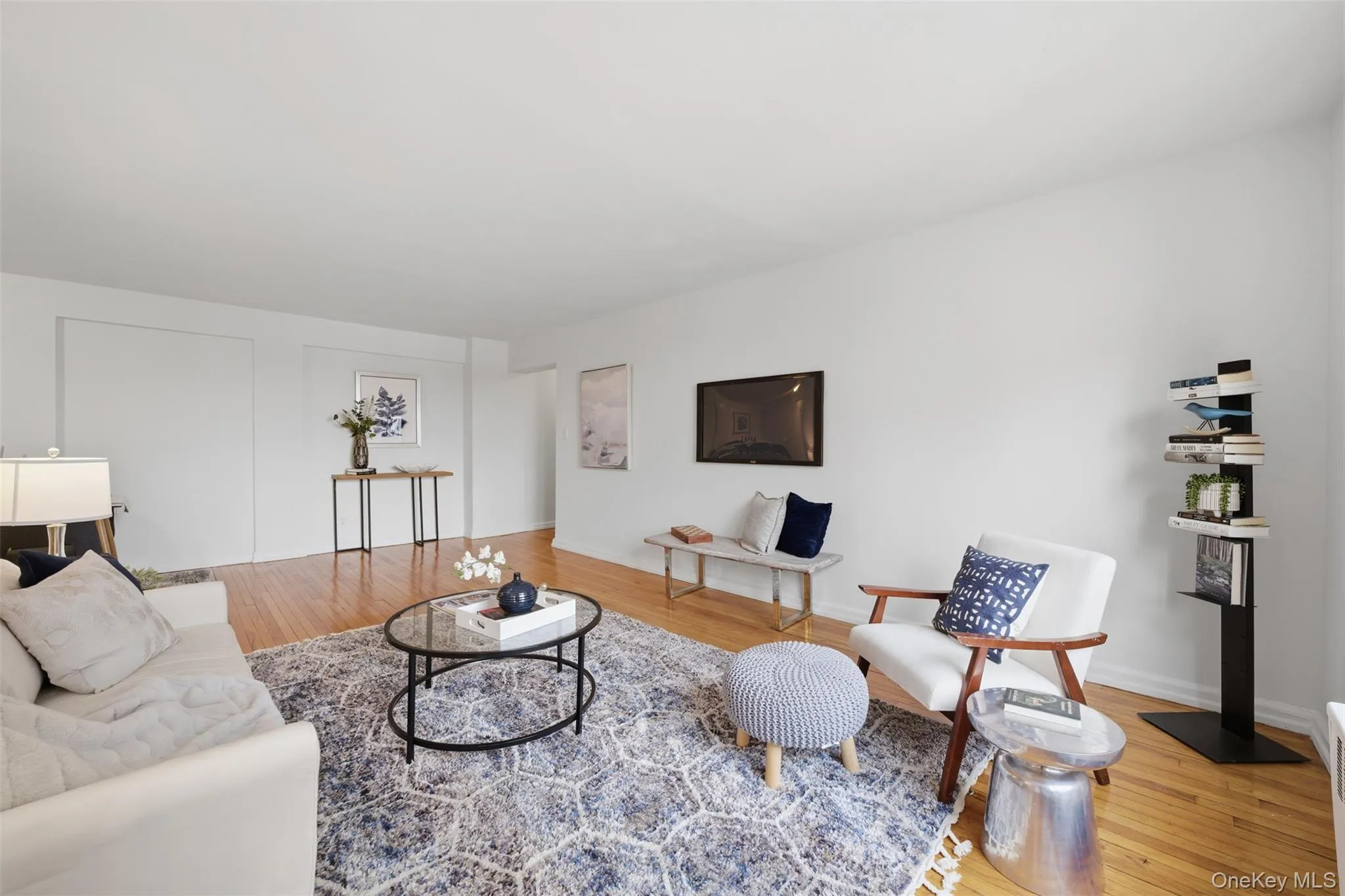 Bright living room with hardwood floors and seamless access to a private balcony showcasing Hudson River views. Bright living room with hardwood floors and seamless access to a private balcony showcasing Hudson River views.