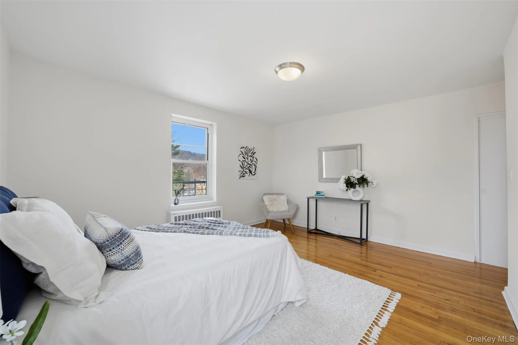 Spacious primary bedroom with two windows, including one overlooking the Hudson River, hardwood floors, and a private en-suite bathroom. Spacious primary bedroom with two windows, including one overlooking the Hudson River, hardwood floors, and a private en-suite bathroom.
