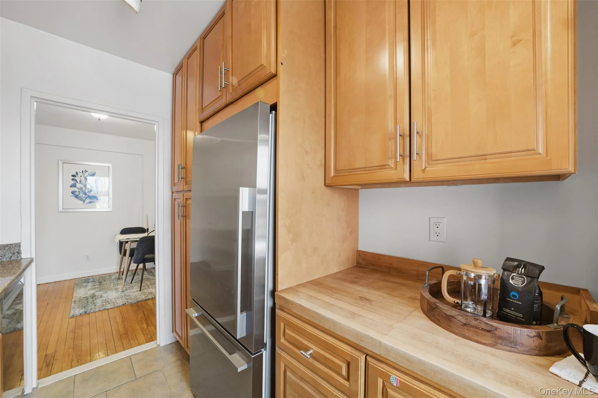 Kitchen featuring stainless steel appliances, wood cabinetry, light stone countertops, and a natural wood prep surface, with Hudson River views. Kitchen featuring stainless steel appliances, wood cabinetry, light stone countertops, and a natural wood prep surface, with Hudson River views.